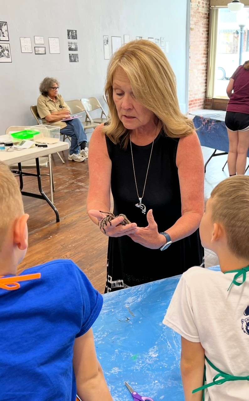 Brenda Meder shows children a tarantula during one of the Hays Arts Center's children's summer art classes in 2023. Courtesy photo