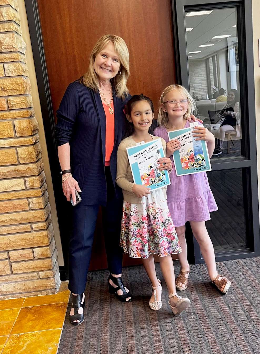 Brenda Meder poses for a photo with two winners of the Hays Arts Council Youth Creative Writing Awards. Courtesy photo