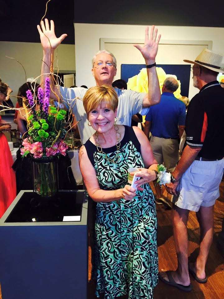 Brenda Meder at a flower-inspired art exhibit at the Hays Arts Center with artist Michael Jilg, photobombing in the background. Courtesy photo
