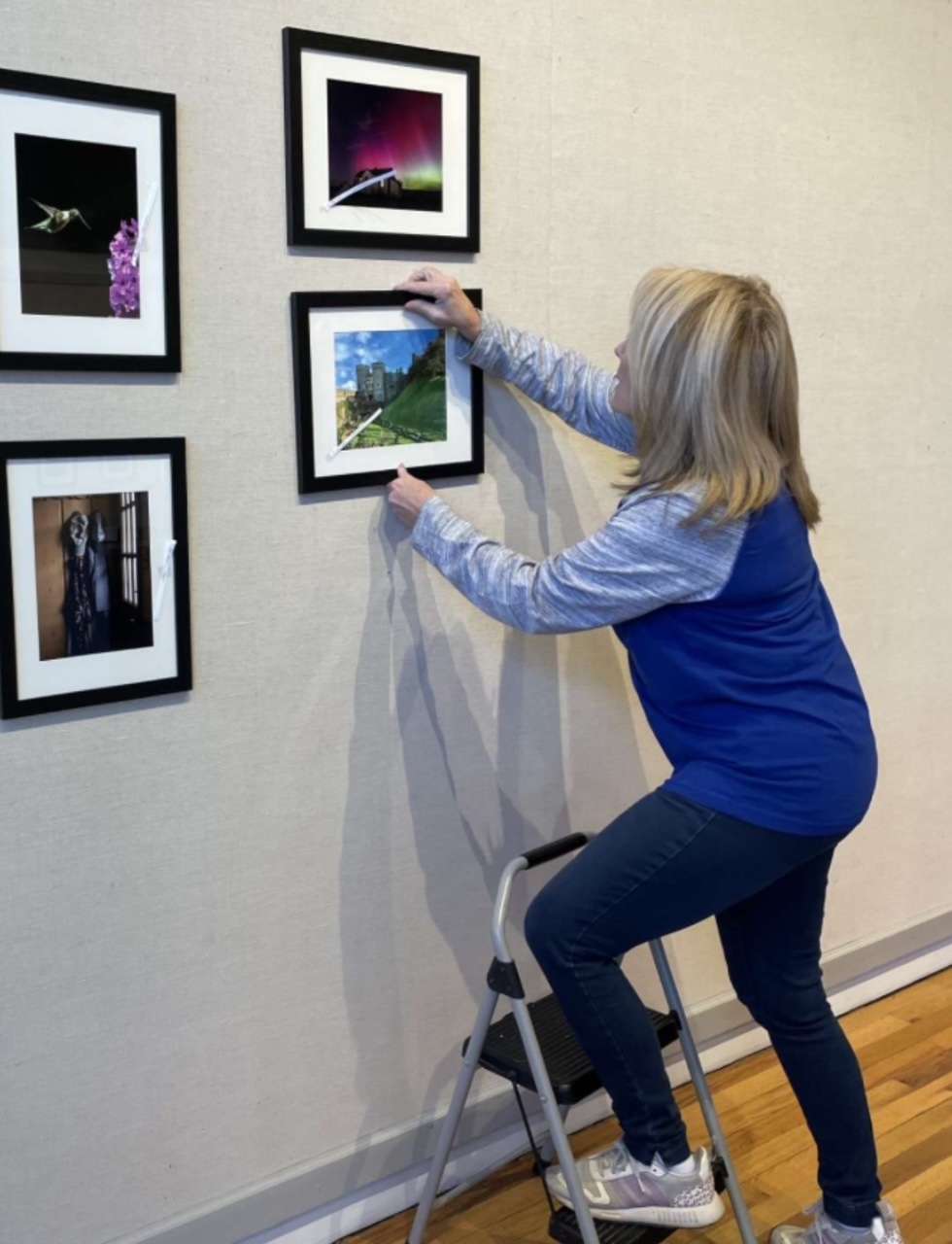 Brenda Meder hanging an art show at the Hays Arts Center. Artist Michael Jilg said Meder has an eye for knowing how art should go together. Courtesy photo