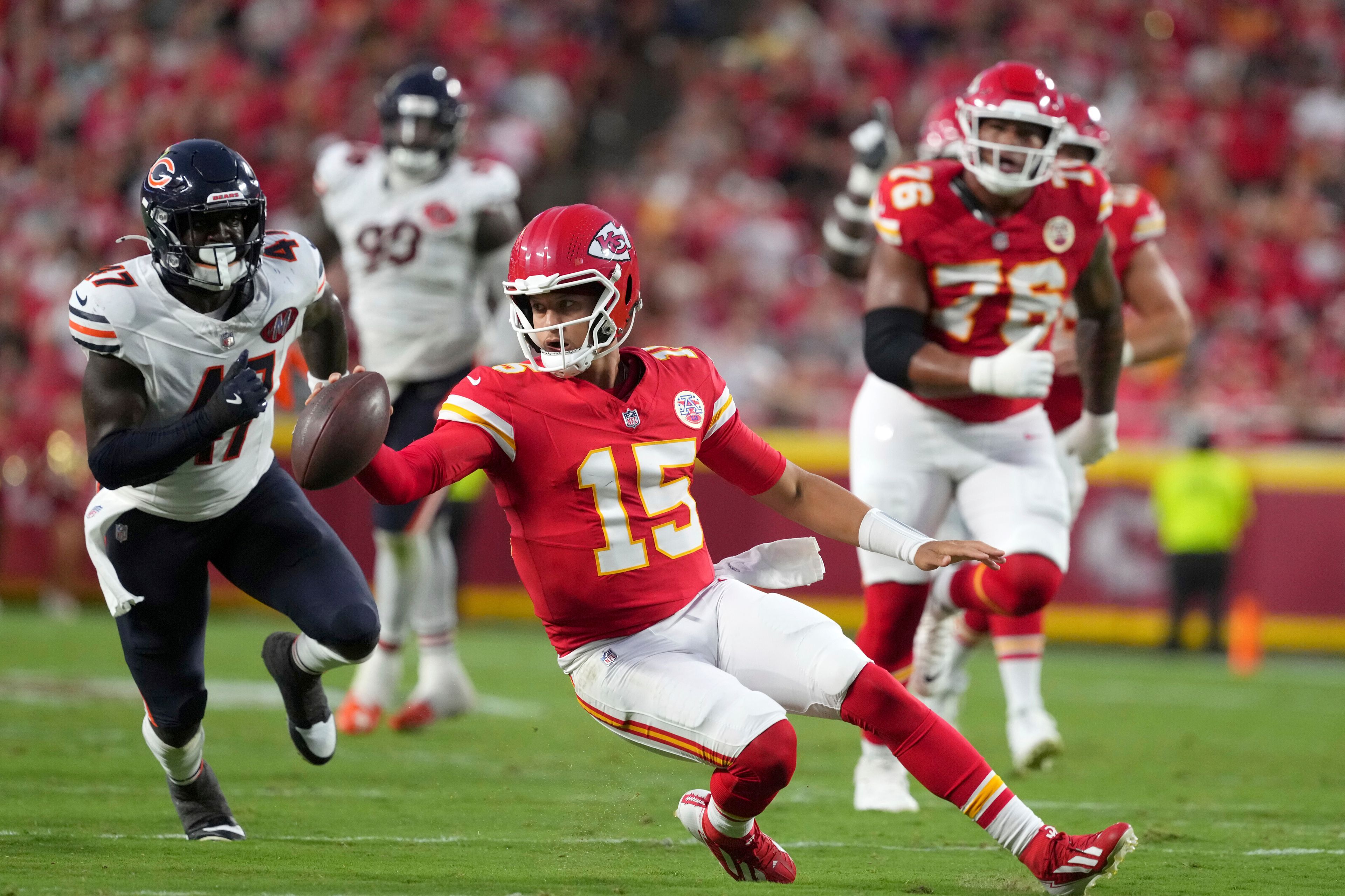 Kansas City Chiefs quarterback Patrick Mahomes (15) scrambles as Chicago Bears linebacker Ruben Hyppolite II (47) defends during the first half of a preseason NFL football game Friday, Aug. 22, 2025, in Kansas City, Mo. (AP Photo/Ed Zurga)