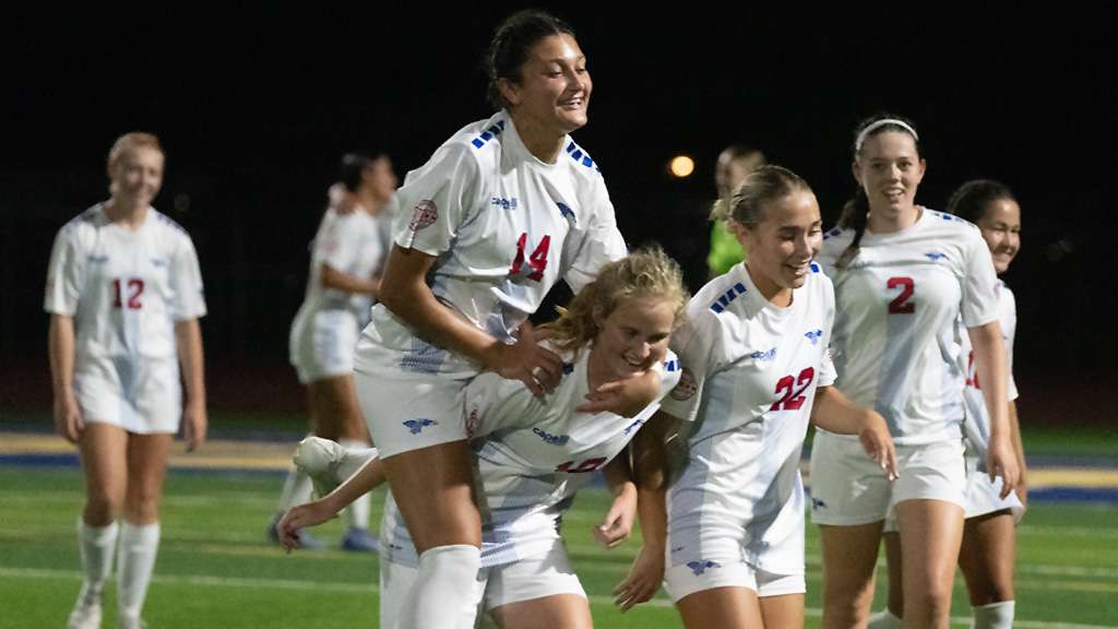 Poppy Smith (10) is mobbed by Blue Dragon teammates after scoring the game-winning goal with 12.2 second remaining in a 2-1 season-opening victory over No. 12 Trinity Valley on Monday at Don Michael Field (Andrew Carpenter/Digital Fox photography)