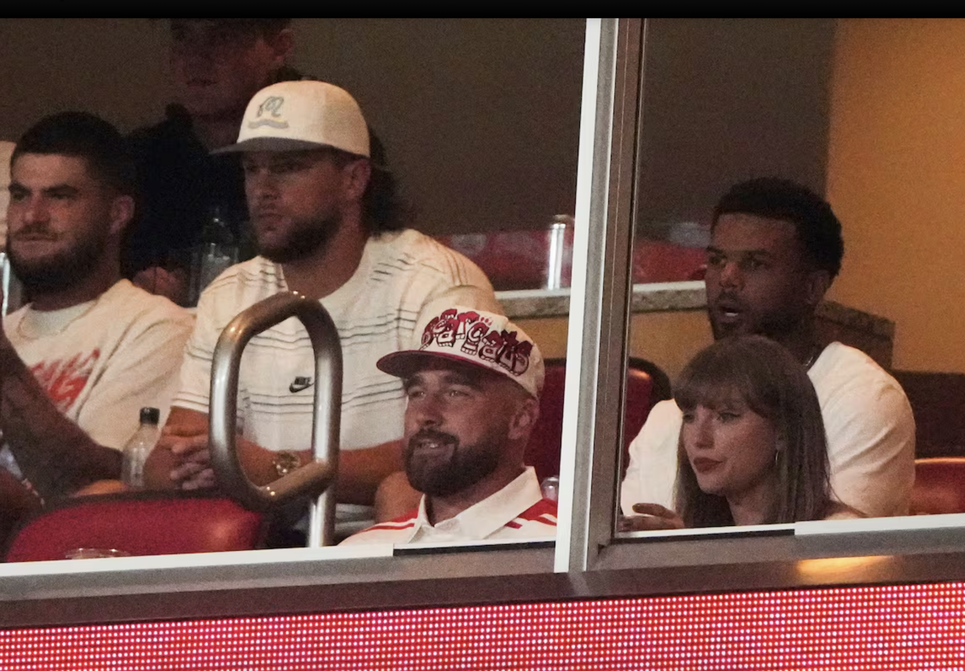 Taylor Swift, front right, sits with fiance Travis Kelce, second from front left, as they watch the first half of an NCAA college football game between Cincinnati and Nebraska, Thursday, Aug. 28, 2025, at Arrowhead Stadium in Kansas City, Mo. (AP Photo/Charlie Riedel)
