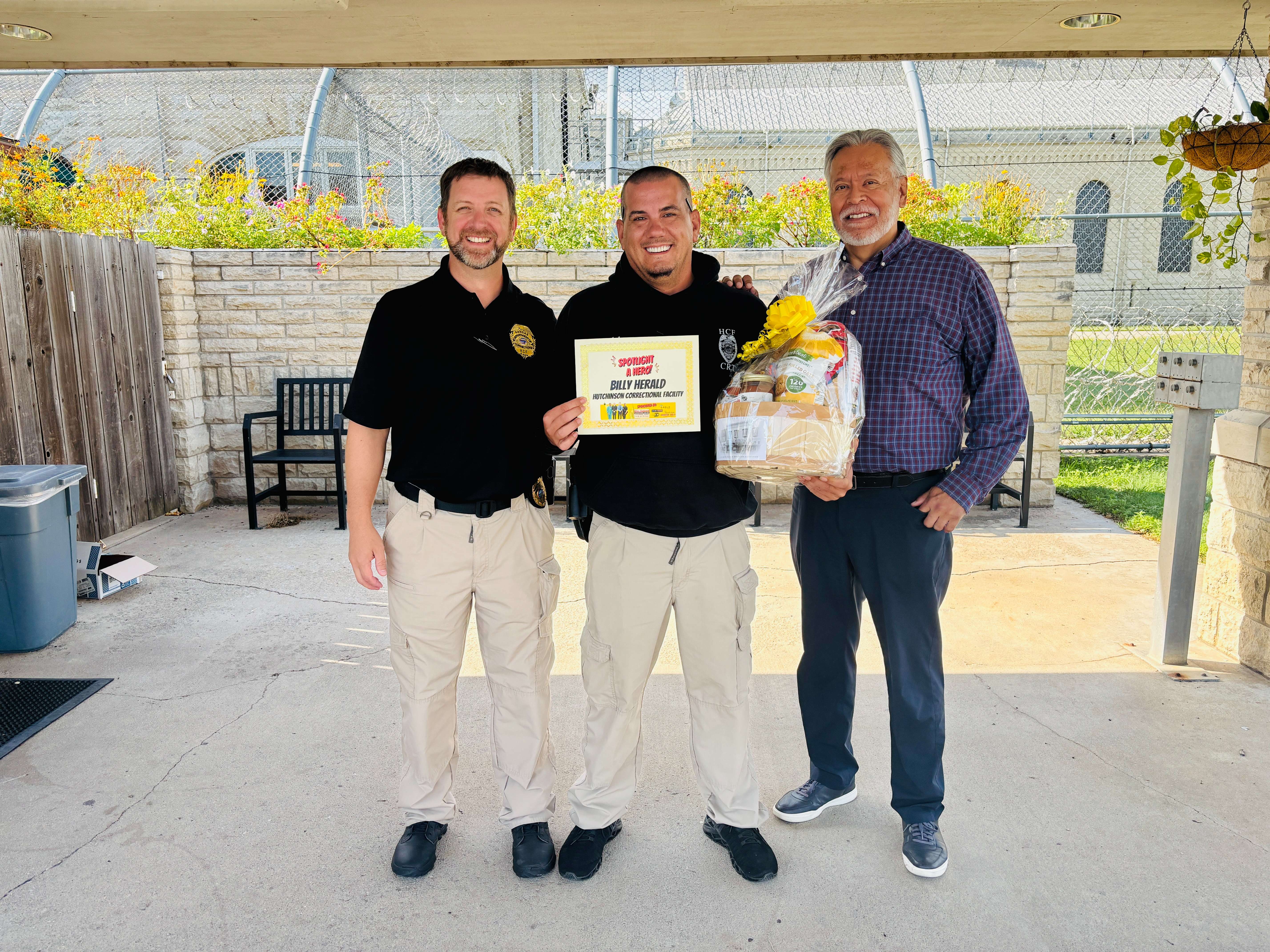 Correctional officer Billy Herald, center, is honored as the Allen Samuels Chrysler Dodge Jeep Ram First Responder of the Month at the Hutchinson Correctional Facility. Also pictured are Jordan Bell, left, major and public information officer, and Robert Vieyra, right, deputy warden of operations.