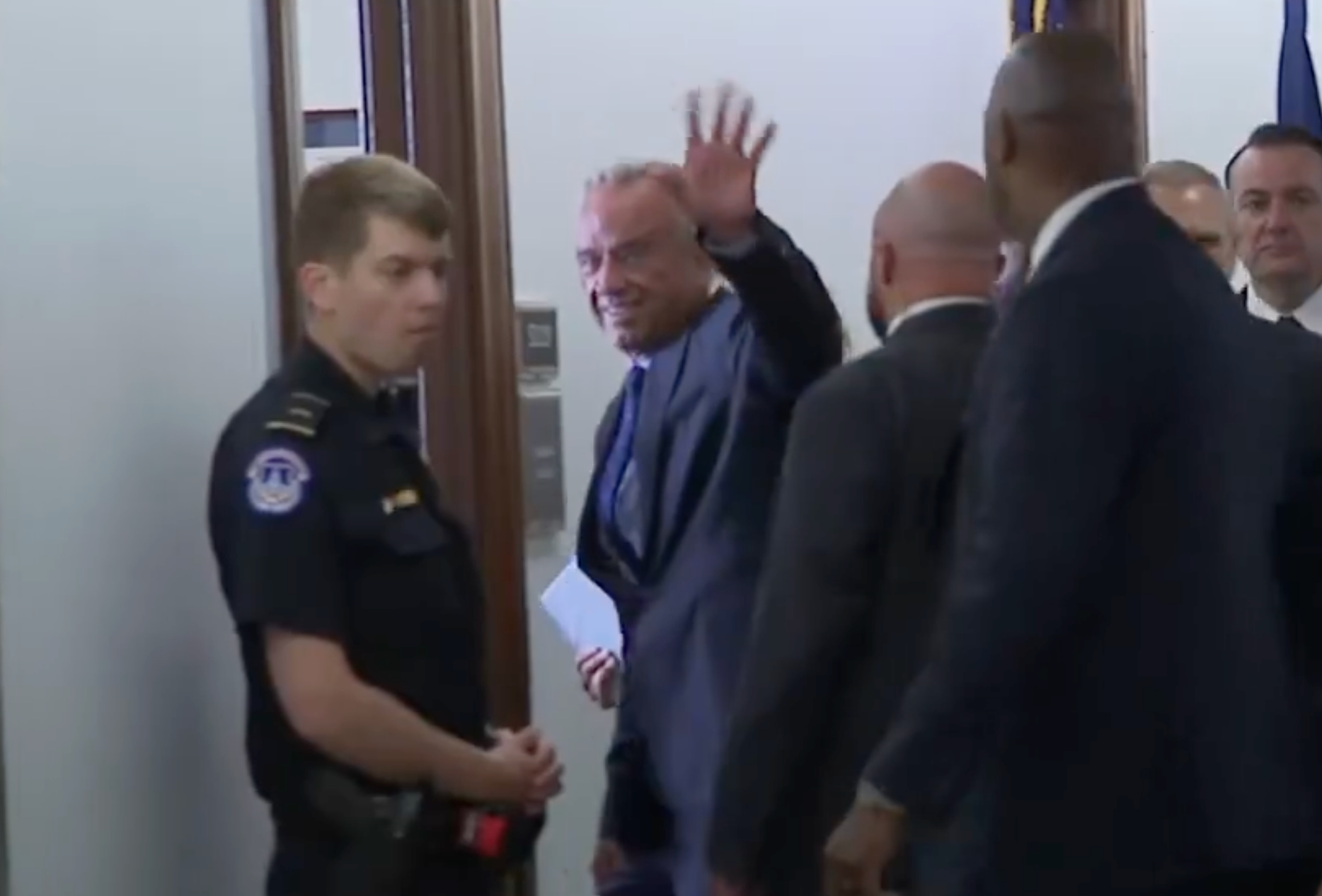Kennedy waved at protesters and supporters as he entered the hearing room on Thursday -image from CSPAN video