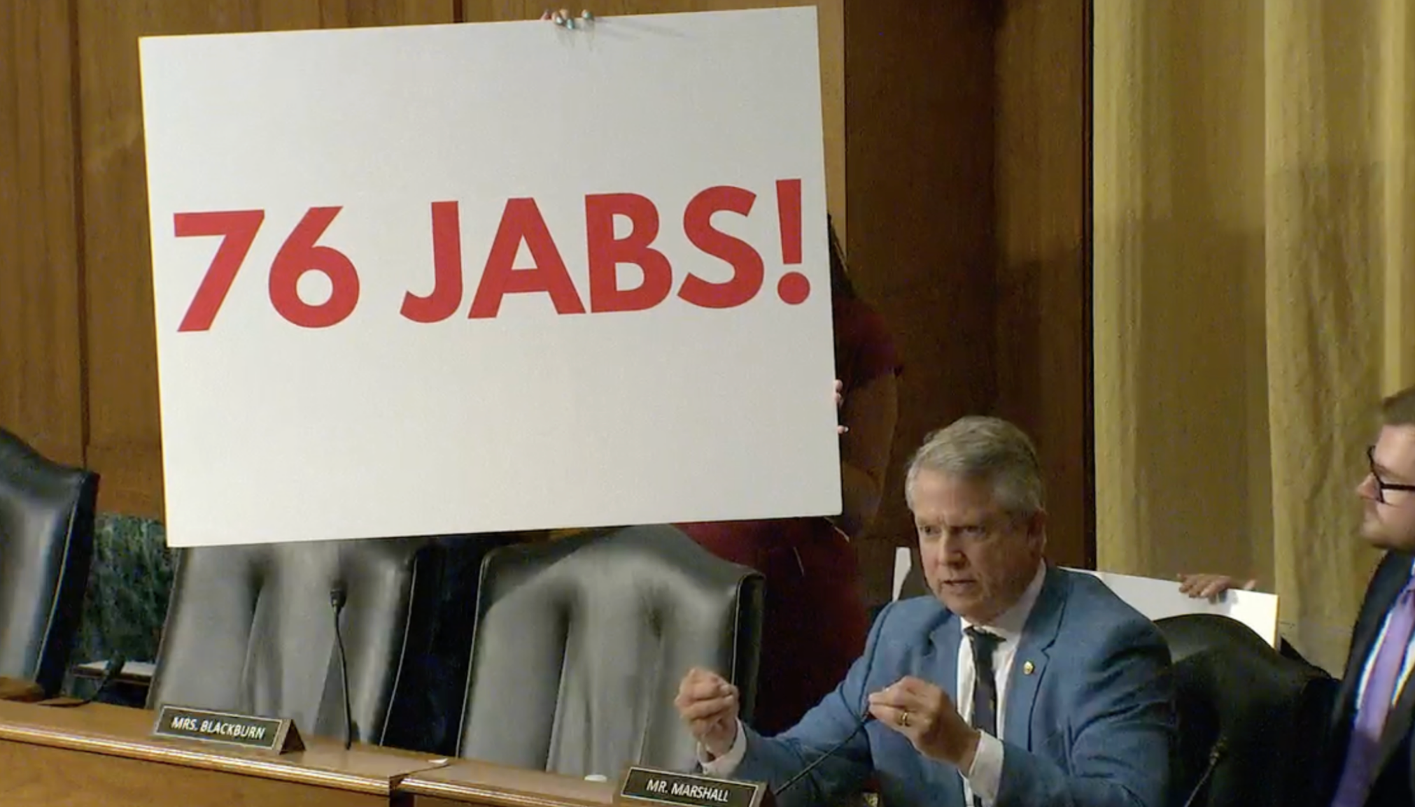 Republican U.S. Sen. Roger Marshall of Kansas describes, with signage, the number of vaccines U.S. children typically receive by the age of 18 during a Sept. 4, 2025, hearing of the U.S. Senate Finance Committee. (Kansas Reflector screen capture from U.S. Senate Finance Committee livestream)