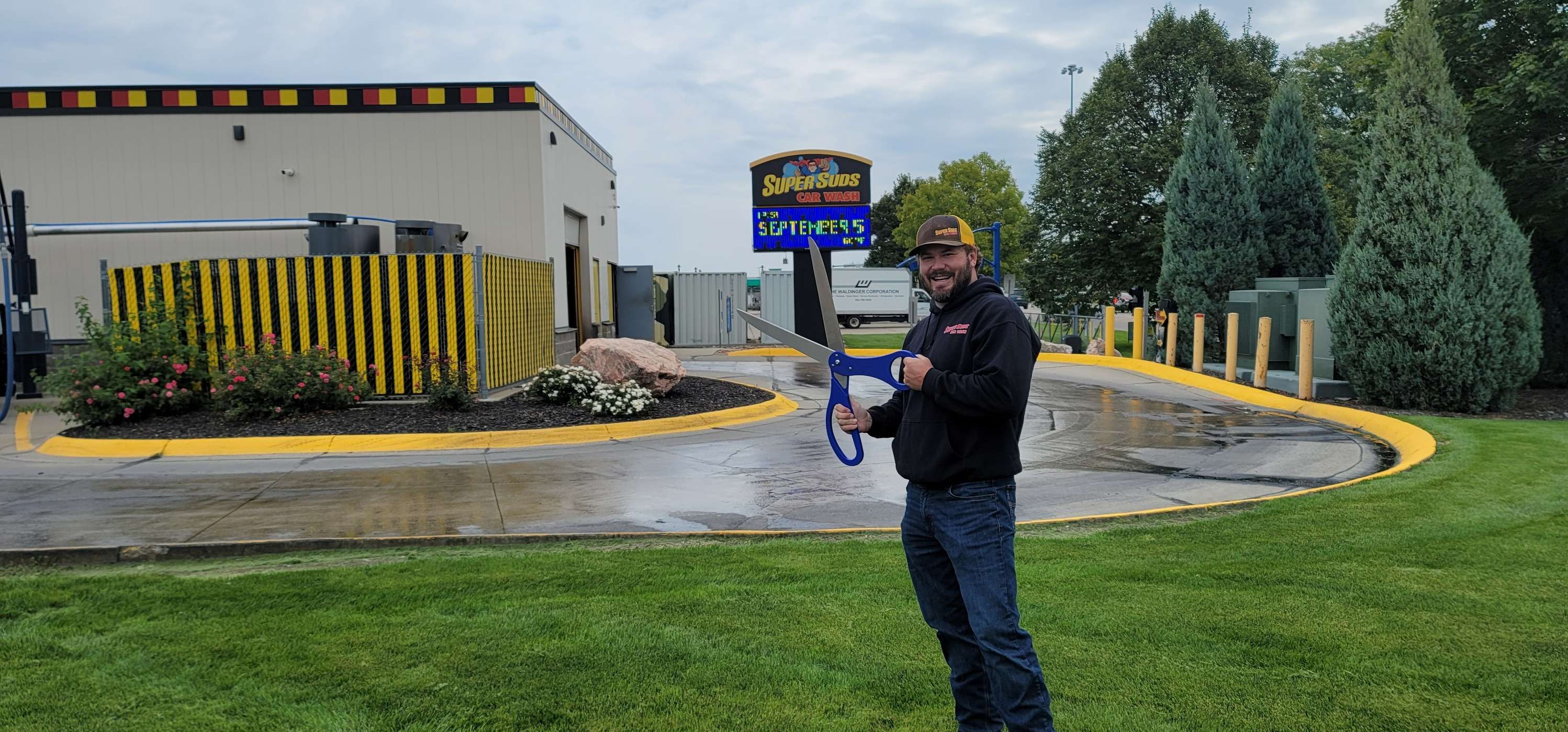 Jake Childers, owner of Super Suds on West Leota Street in North Platte, holds scissors for the Chamber of Commerce ribbon cutting ceremony Sept. 5.