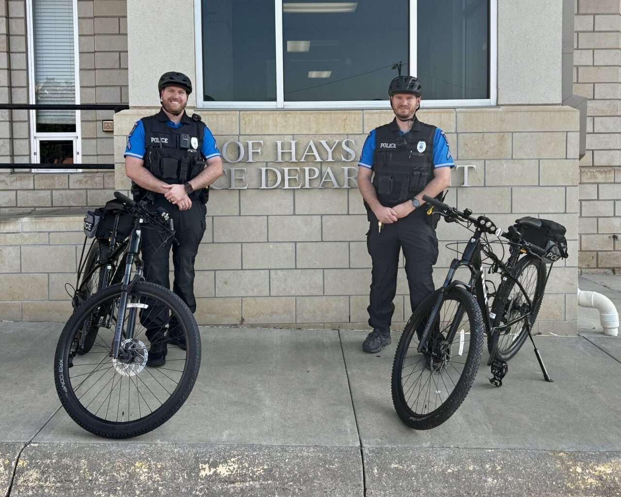 Hays Police Patrol Corporal Alex Broadway (right) and Hays Police Corporal Ethan Henderson (left) with their two patrol bikes. Photo by Tony Guerrero/Hays Post