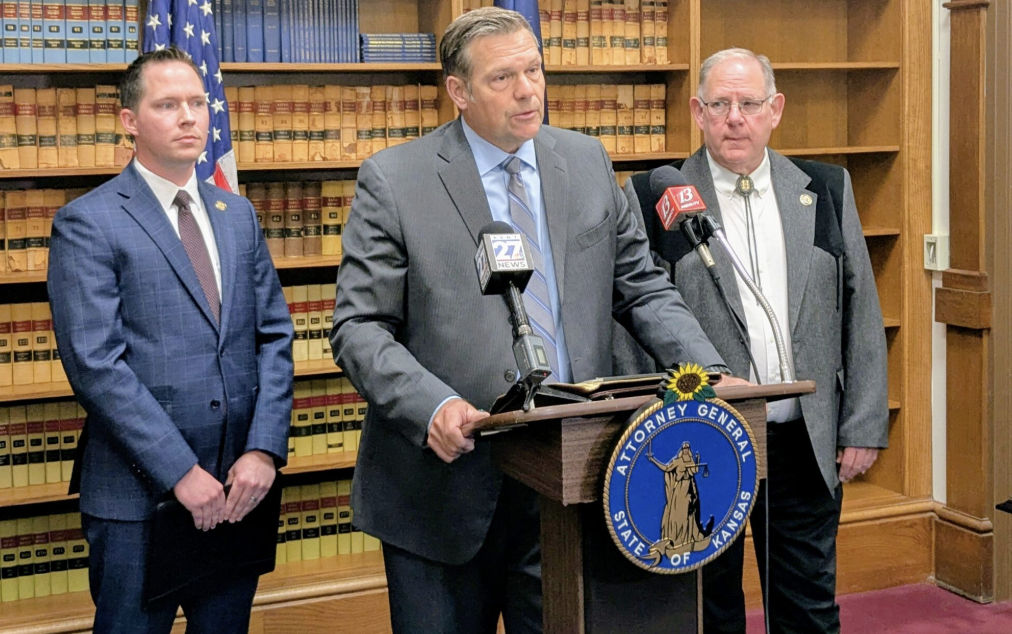 Kansas Attorney General Kris Kobach announced filing of a lawsuit against Gov. Laura Kelly related to demands by the administration of President Donald Trump to release personal information about Kansans enrolled in the SNAP food aid program. Joining Kobach at a news conference were state Senate Majority Leader Chase Blasi, left, and House Speaker Dan Hawkins, right. (Tim Carpenter/Kansas Reflector)