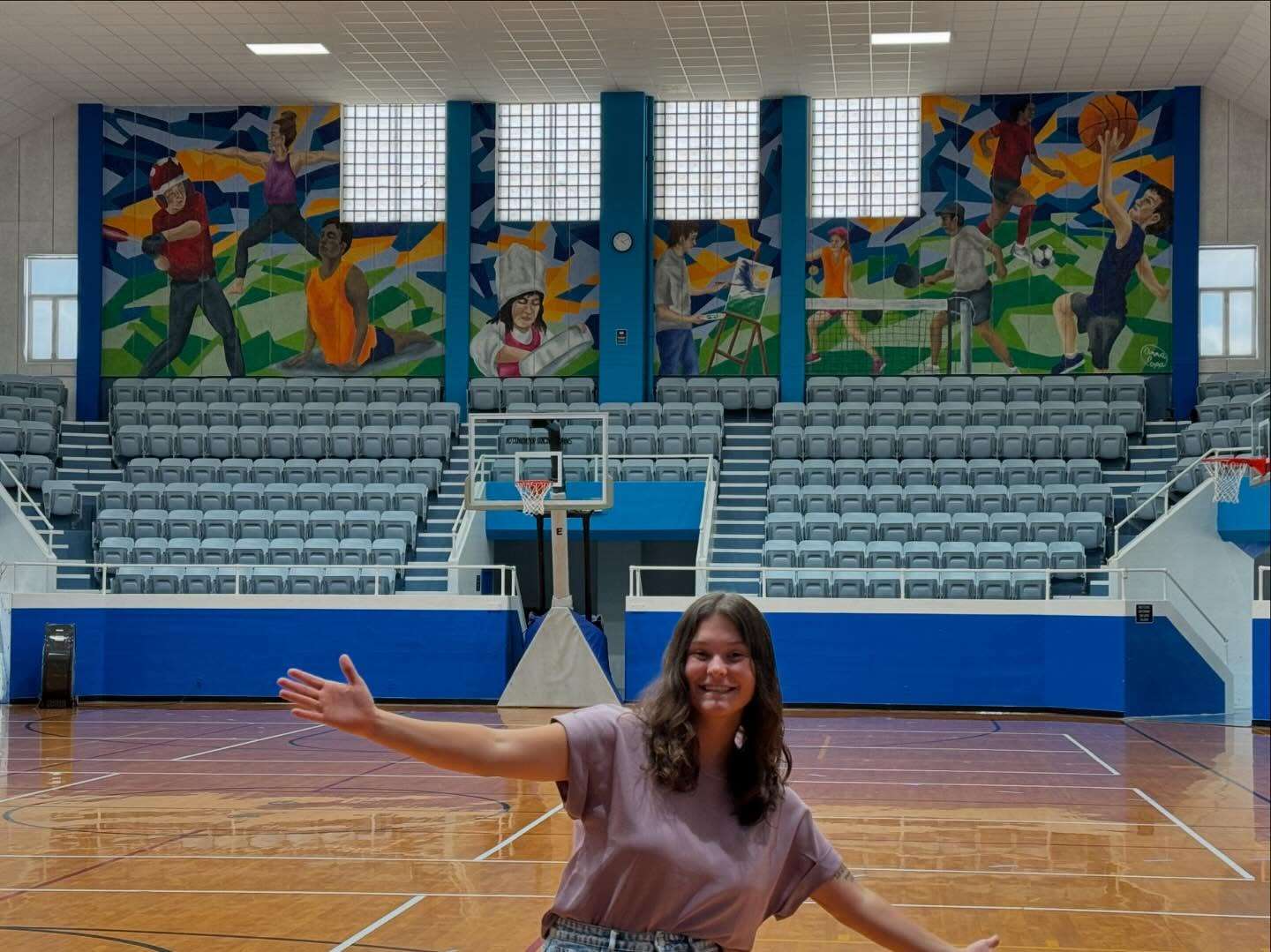 Popp, pictured with a large-scale mural she painted inside the Great Bend City Auditorium. In addition to her role as GBHS Art Teacher, Popp is currently working on her 12th community mural.