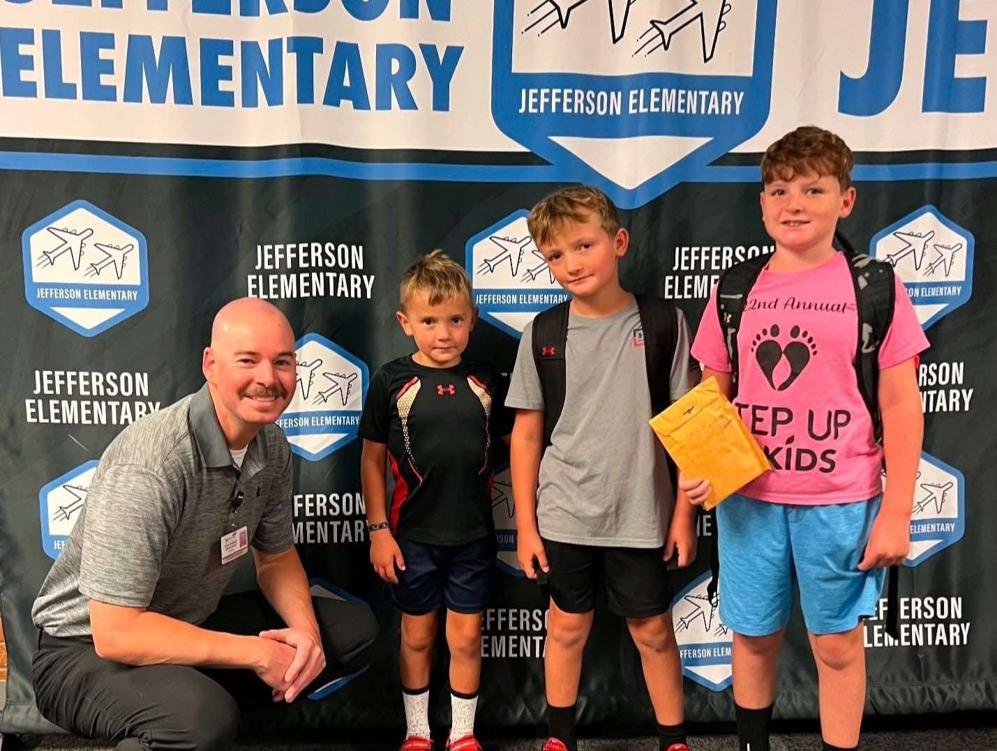 Jefferson Elementary Principal Adam Niedens with Mason, Wesley, and Brock Bauer. The trio of brothers raised $111 at a lemonade stand this summer and donated the money to the their school lunch program.