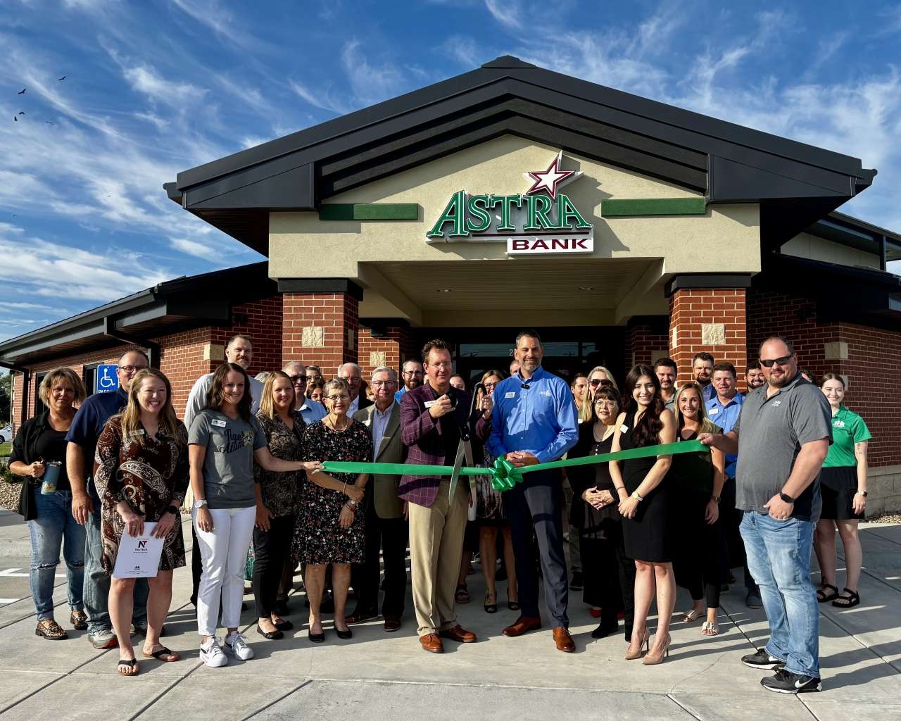 Jason Kennedy, Astra Bank market president, and the CEO of Astra Bank, Kyle Campbell, surrounded by family, staff and community members during the Astra Bank ribbon-cutting ceremony in Hays. Photo by Tony Guerrero/Hays Post