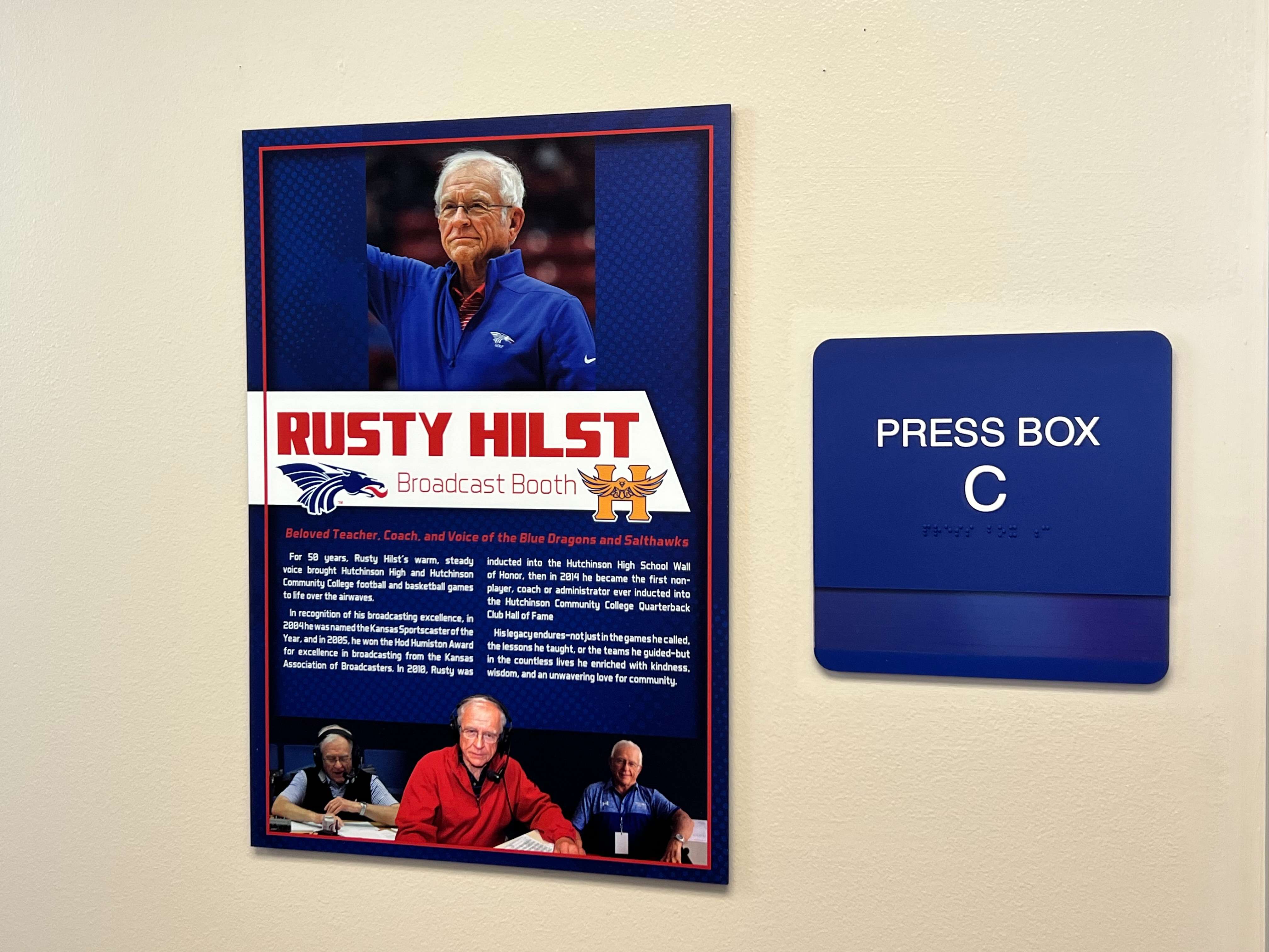 Press Box Suite C at Gowans Stadium was dedicated Friday as the Rusty Hilst Broadcast Booth in honor of the longtime radio voice of Hutchinson High and Hutchinson Community College football and basketball. Hilst, who passed away in June after a battle with ALS, spent decades on the air calling Blue Dragon and Salthawk games. (Hutch Post Photo/Sean Boston)
