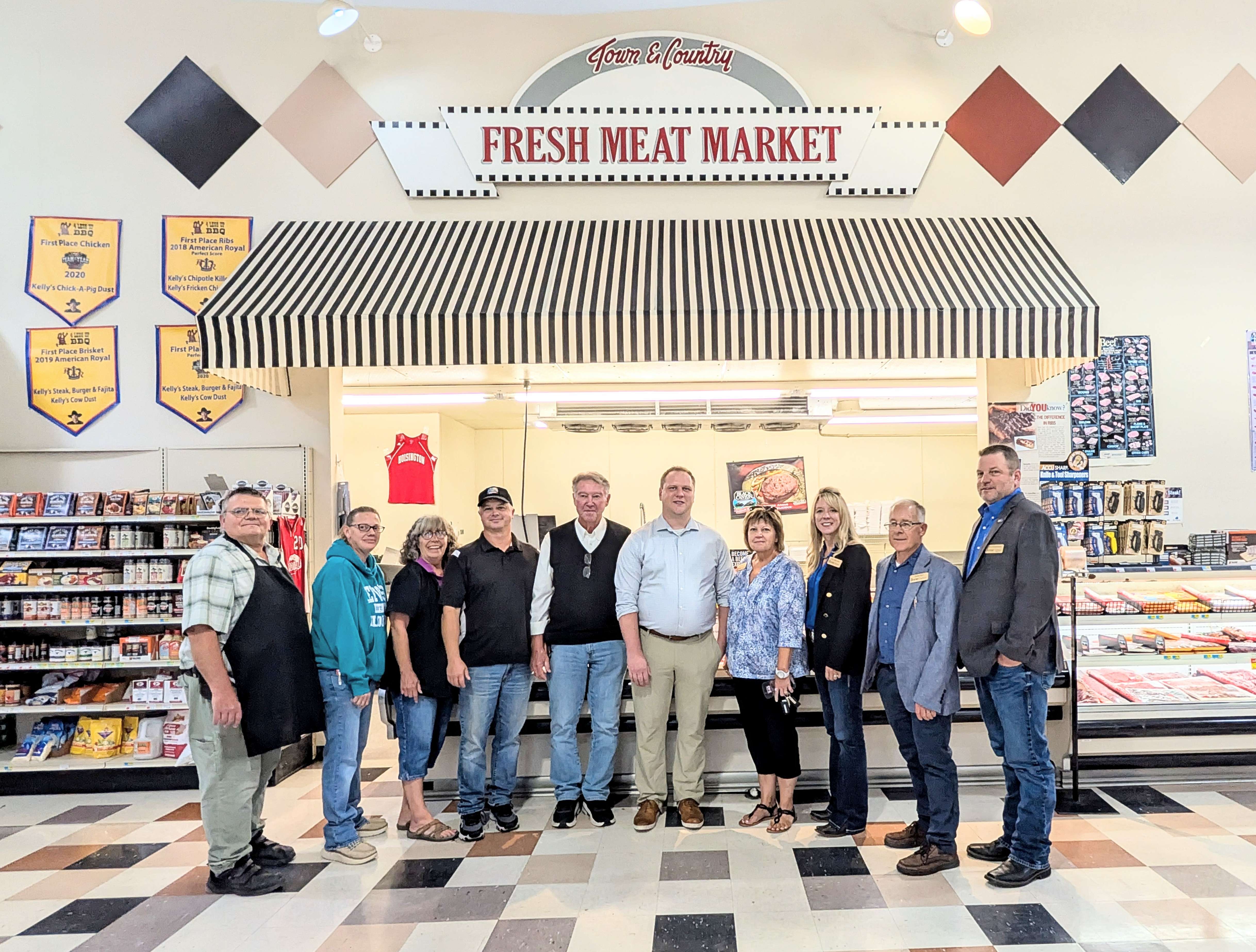 Barton County commissioners Donna Zimmerman, Tricia Schlessiger, Duane Reif and Shawn Hutchinson, and County Administrator Matt Patzner, join team members from Town and Country Supermarket, including Richard Tittel, Joy Gisick, Carma Strayer, Lance Shepard and Randy Deutsch, who owns the store along with his wife Debbie. Deutsch touted their meat counter where all the meat is fresh and locally cut, and prices are competitive with large chain stores.