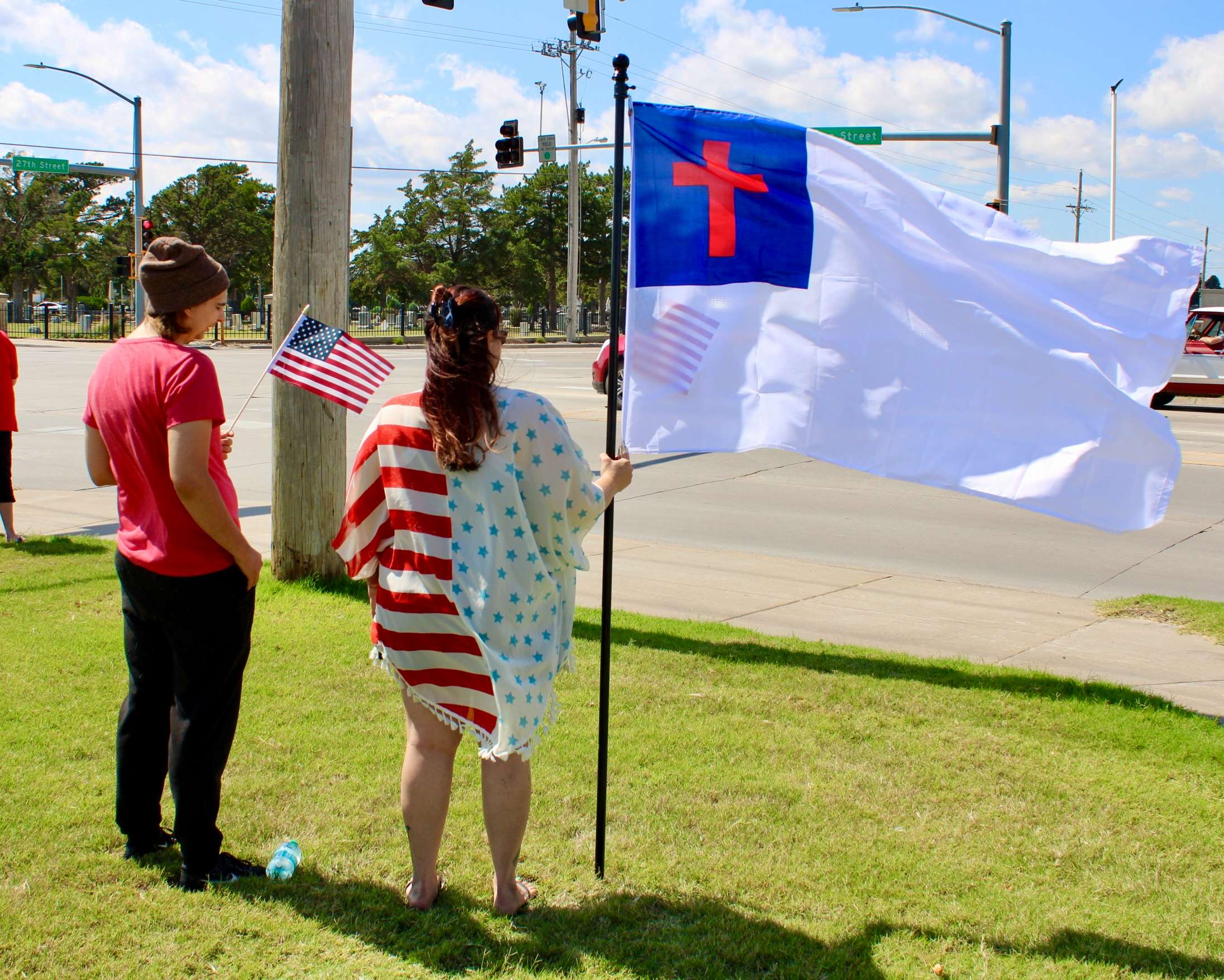 Attendees with flags on the corner of 27th and Vine in Hays. Photo by Tony Guerrero/Hays Post
