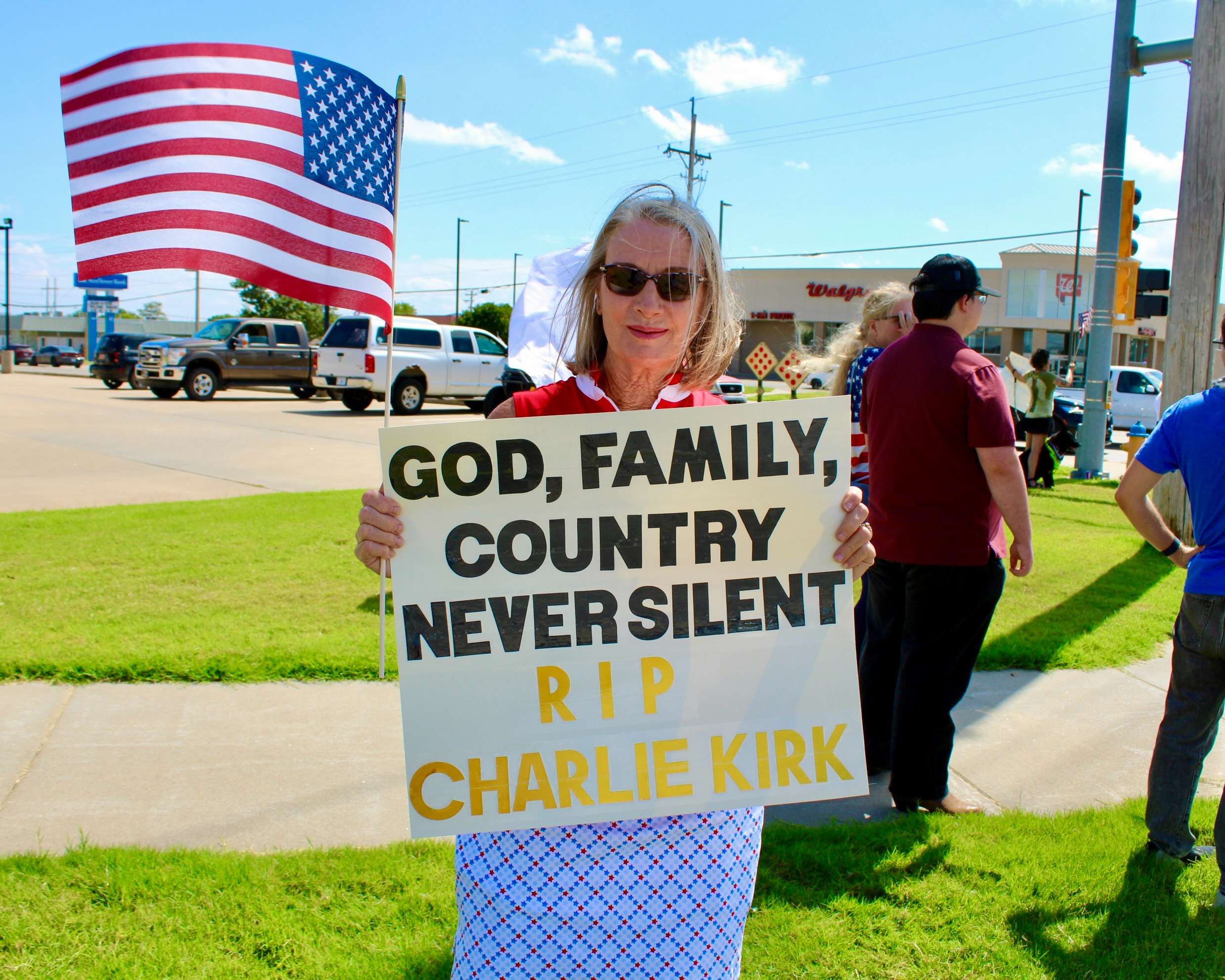An attendee with a sign on the corner of 27th and Vine in Hays. Photo by Tony Guerrero/Hays Post