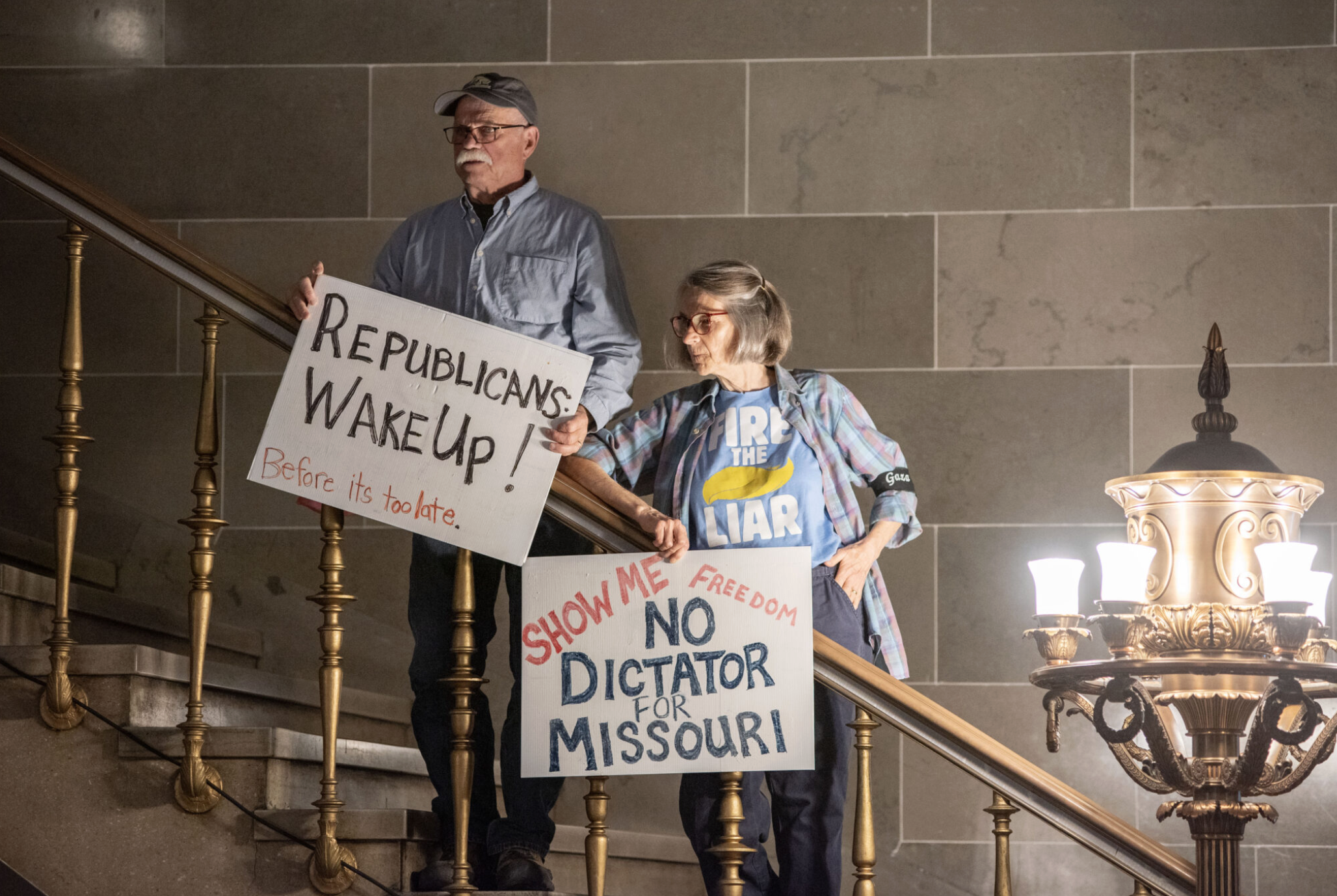 David Fortel and Hope Tinker hold homemade signs during a protest last week in the Missouri Capitol rotunda (Annelise Hanshaw/Missouri Independent).