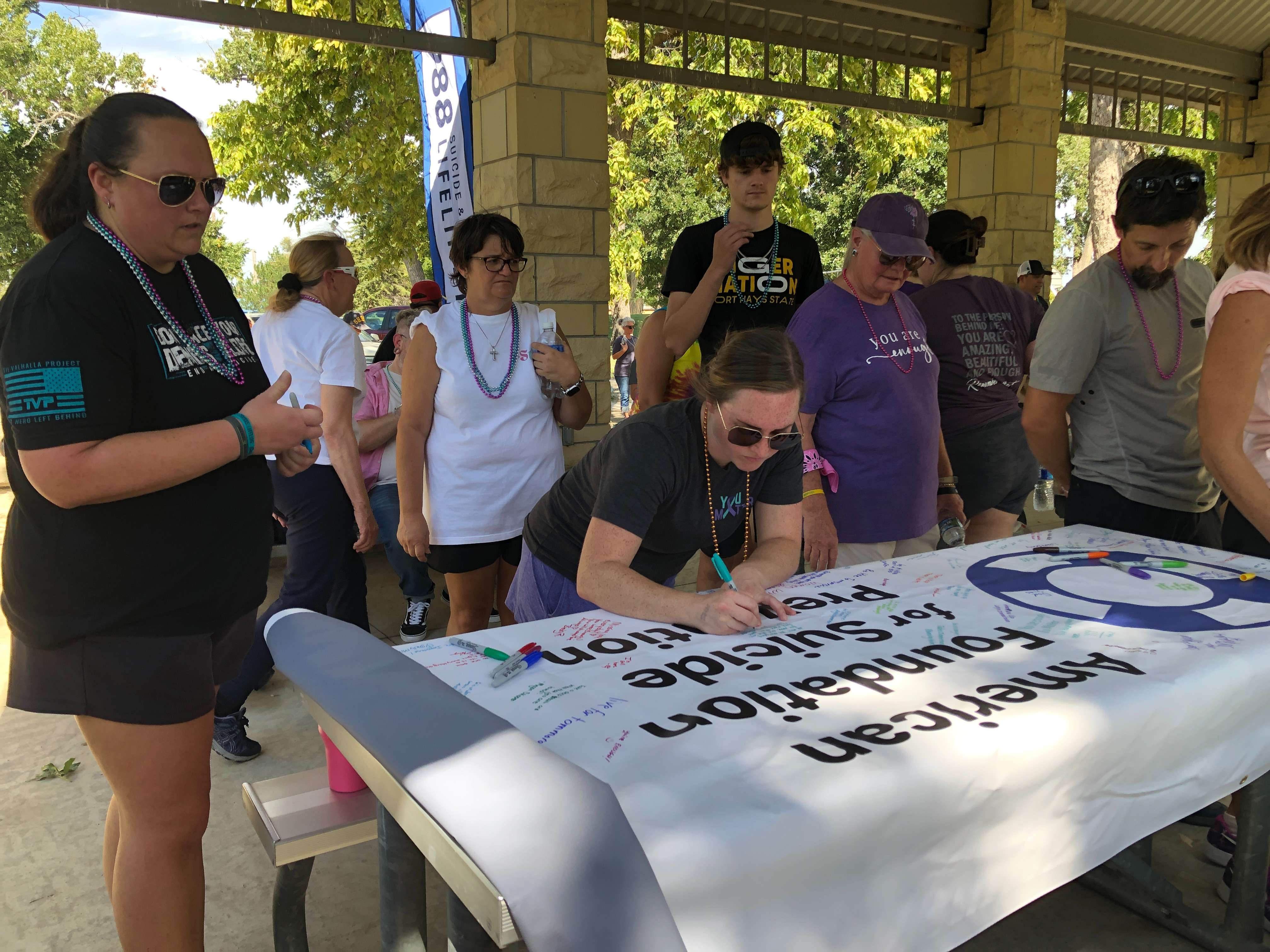 Out of Darkness Walkers sign a banner to promote suicide prevention.&nbsp;Photo by Cristina Janney/Hays Post