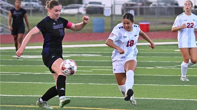 Olivia Tamaki (18) drives a shot past a Dodge City defender for one of her two first-half goals on Wednesday at Don Michael Field. The Blue Dragons were leading 3-1 with 10:19 remaining in the first half when the game was suspended by lightning. (Andrew Carpenter/Digital Fox Photography)