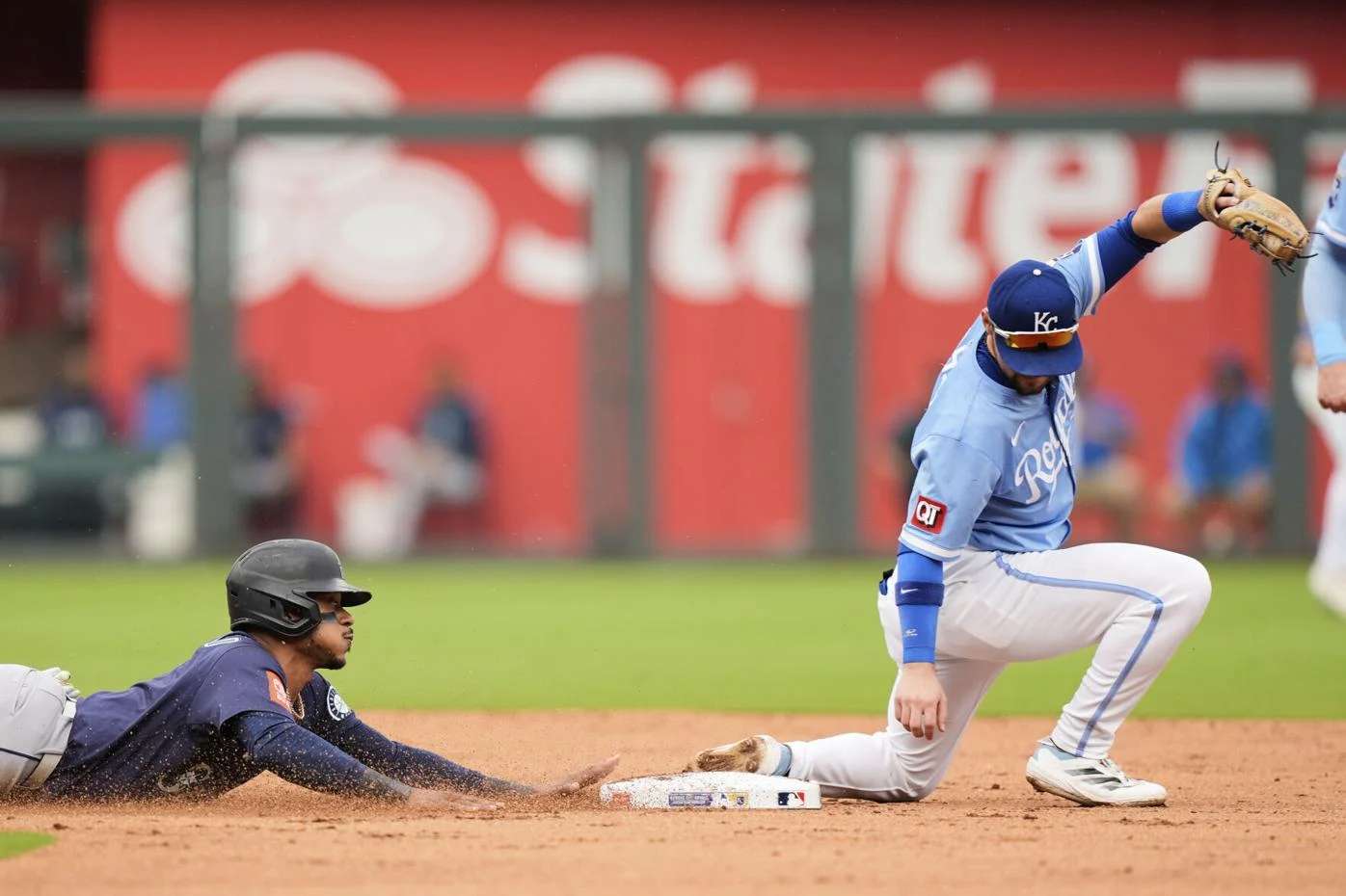 Seattle Mariners' Jorge Polanco, left, is caught off base at second by Kansas City Royals second baseman Michael Massey to get the second out of a double play hit into by Dominic Canzone during the second inning of a baseball game, Thursday, Sept. 18, 2025, in Kansas City, Mo. (AP Photo/Charlie Riedel)
