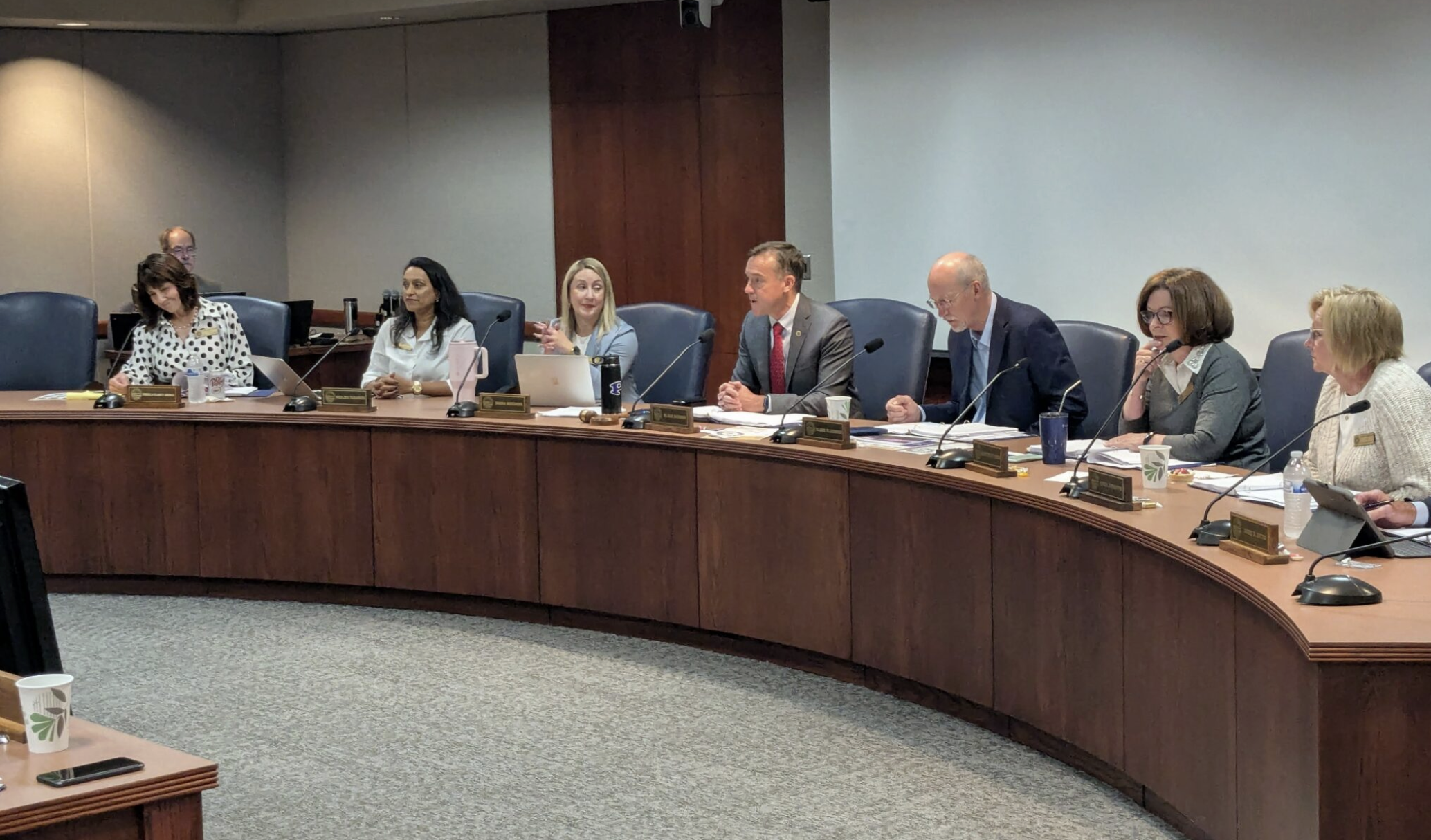  Seven members of the Kansas Board of Regents — there are two vacancies debated the possibility of allowing creation of new 90 credit-hour bachelor’s degree programs at state universities. Board members, from left: Pamela Clancy Ammar, Neelima Parasker, Diana Mendoza, Blake Benson, Blake Flanders (board CEO), Kathy Wolfe Moore and Alysia Johnston. Board member John Dicus isn’t visible. (Tim Carpenter/Kansas Reflector)