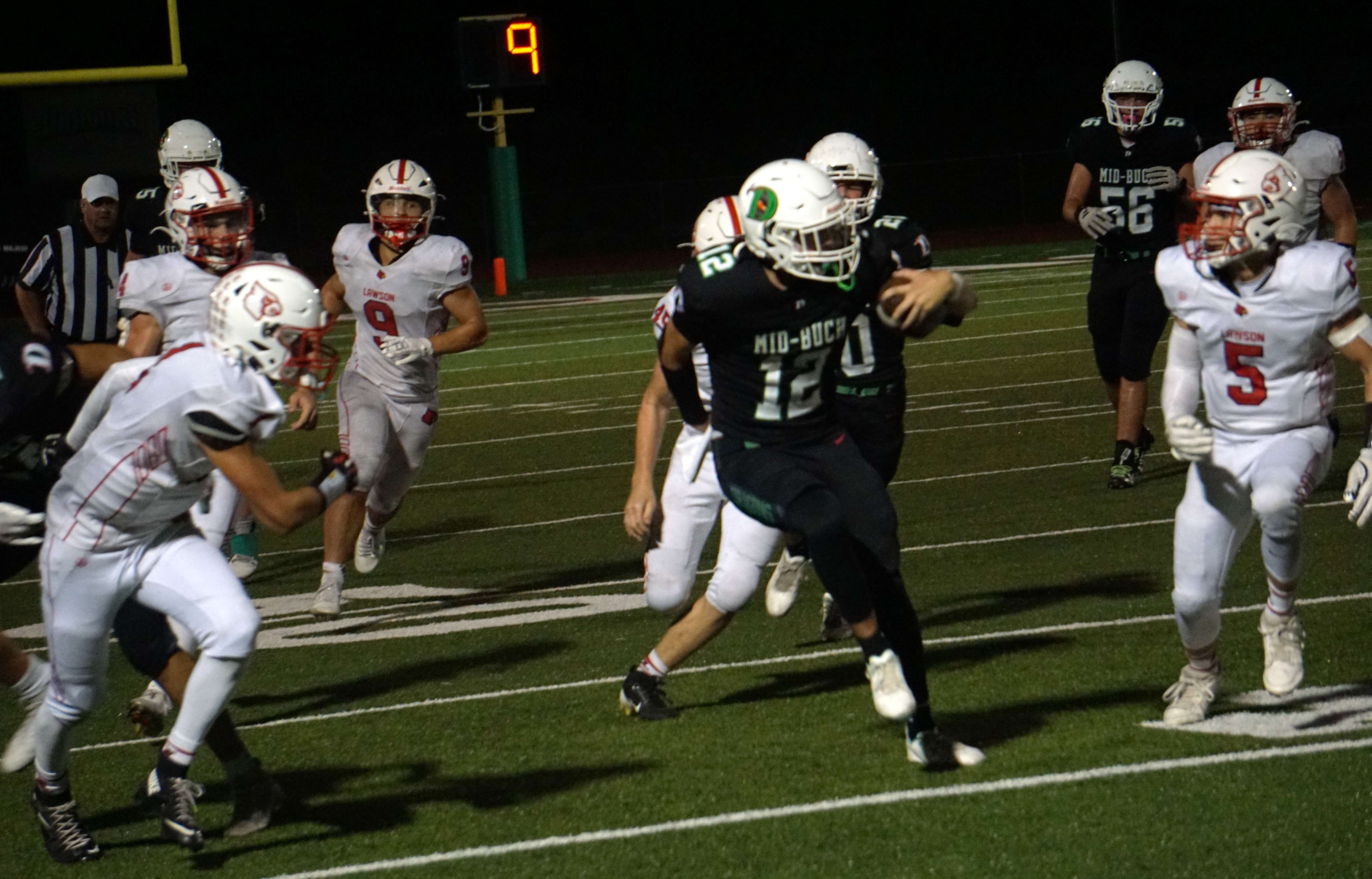 Mid-Buchanan's Raife Smith (12) jukes through several Lawson defenders for a long run/ Photo by Matt PIke