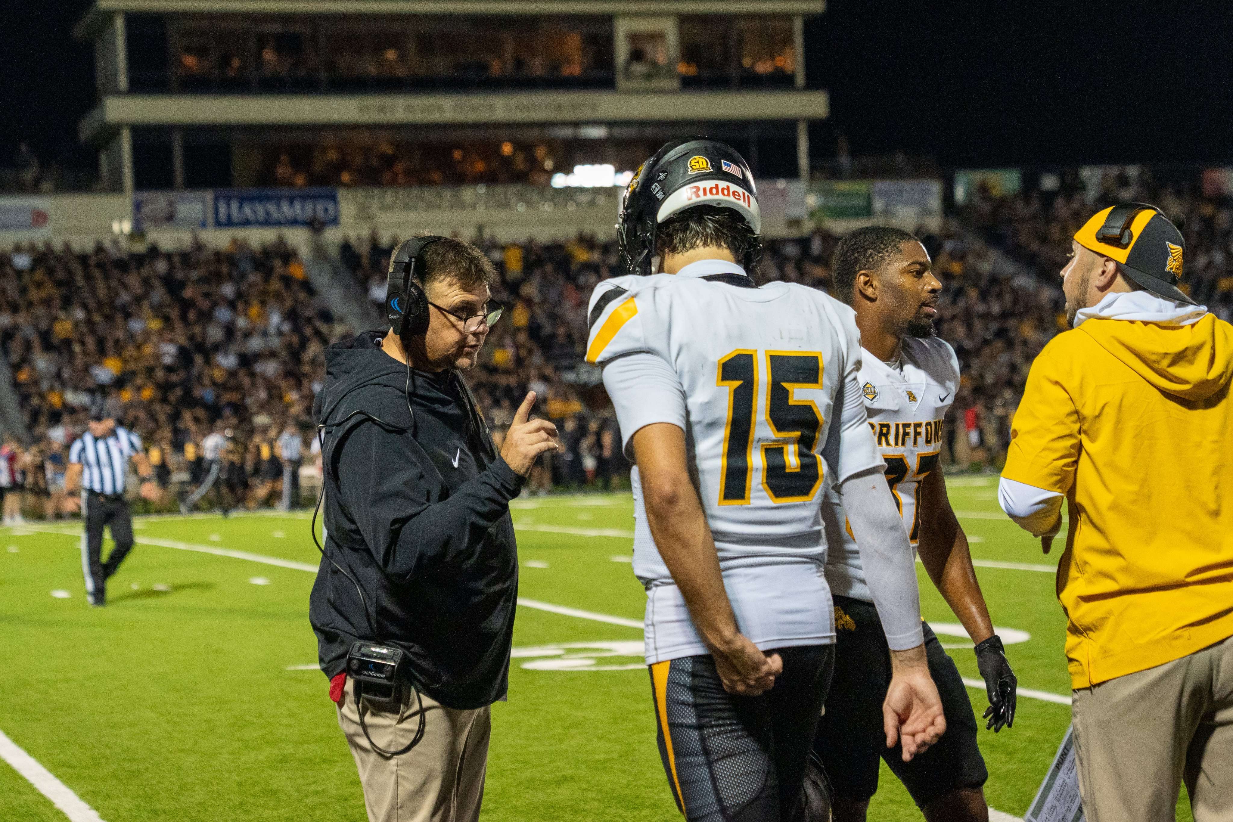 Missouri Western head coach Tyler Fenwick talks to quarterback Kane Donovan on the sideline.  MoWest fell to Fort Hays State 31-23 on the road on Saturday/ Photo courtesy of MoWest Athletics on X