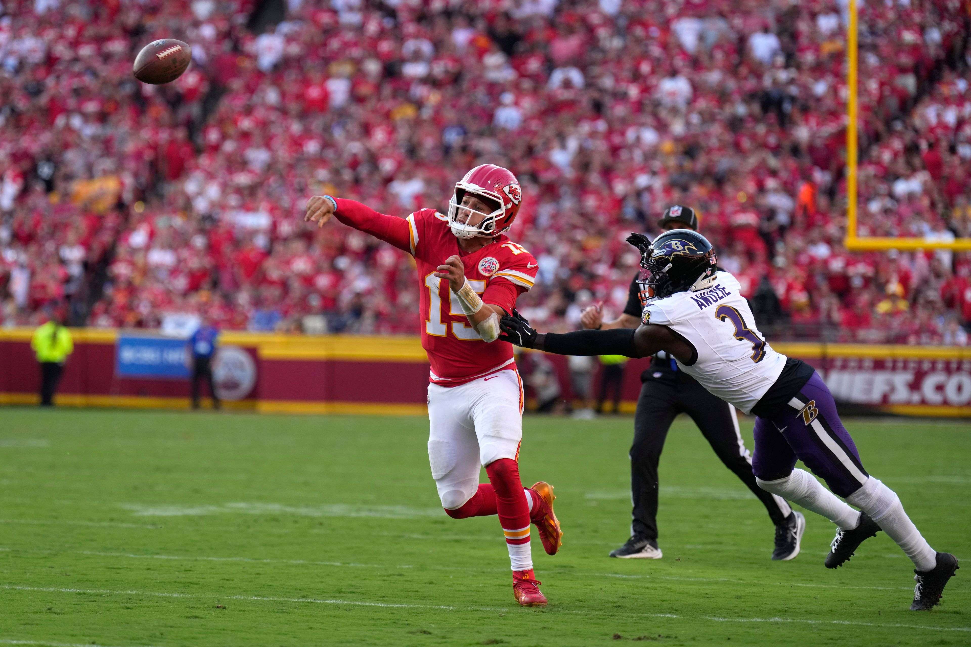 Kansas City Chiefs quarterback Patrick Mahomes (15) throws under pressure from Baltimore Ravens cornerback Chidobe Awuzie (3) during the second half of an NFL football game Sunday, Sept. 28, 2025, in Kansas City, Mo. (AP Photo/Charlie Riedel)
