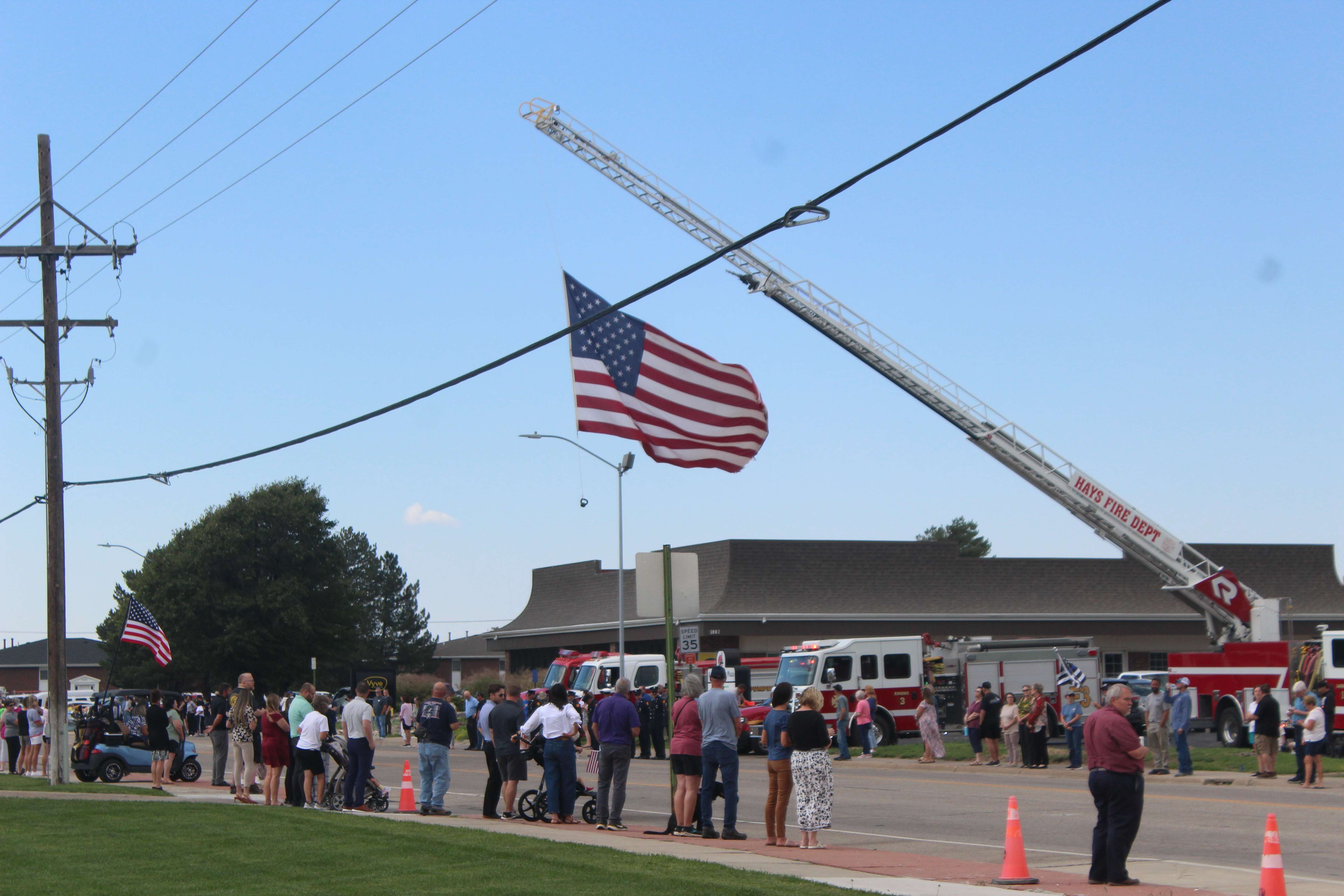 Fire vehicles, firefighters and residents gathered on 27th Street near the corner of 27th and Hall to wait for Sgt. Scott Heimann's escort home. Heimann, a Hays Police officer, was killed in the line of duty on Sunday. Photo by Cristina Janney/Hays Post