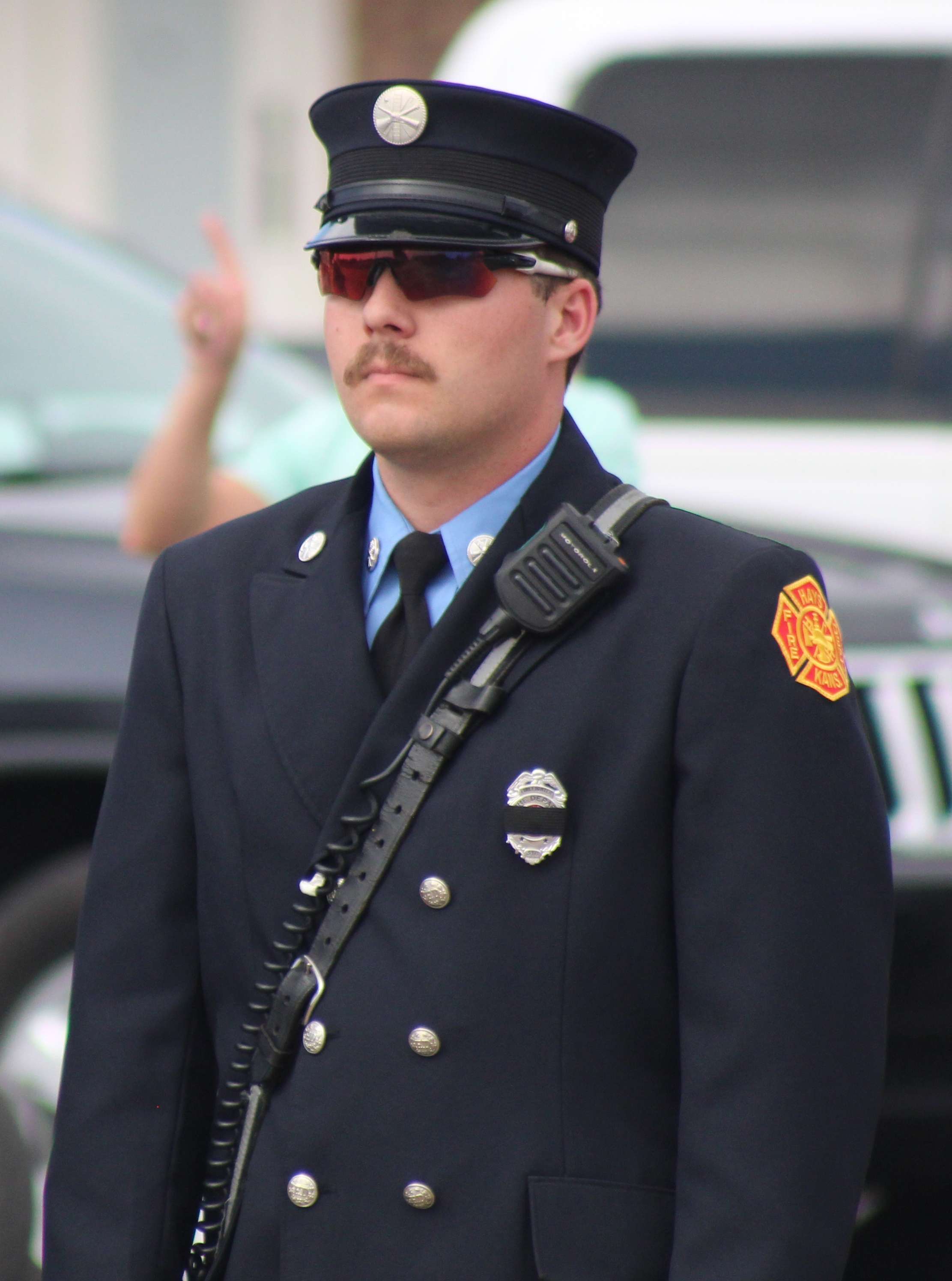 A firefighter standing at attention at Sgt. Scott Heimann's escort. Photo by Cristina Janney/Hays Post