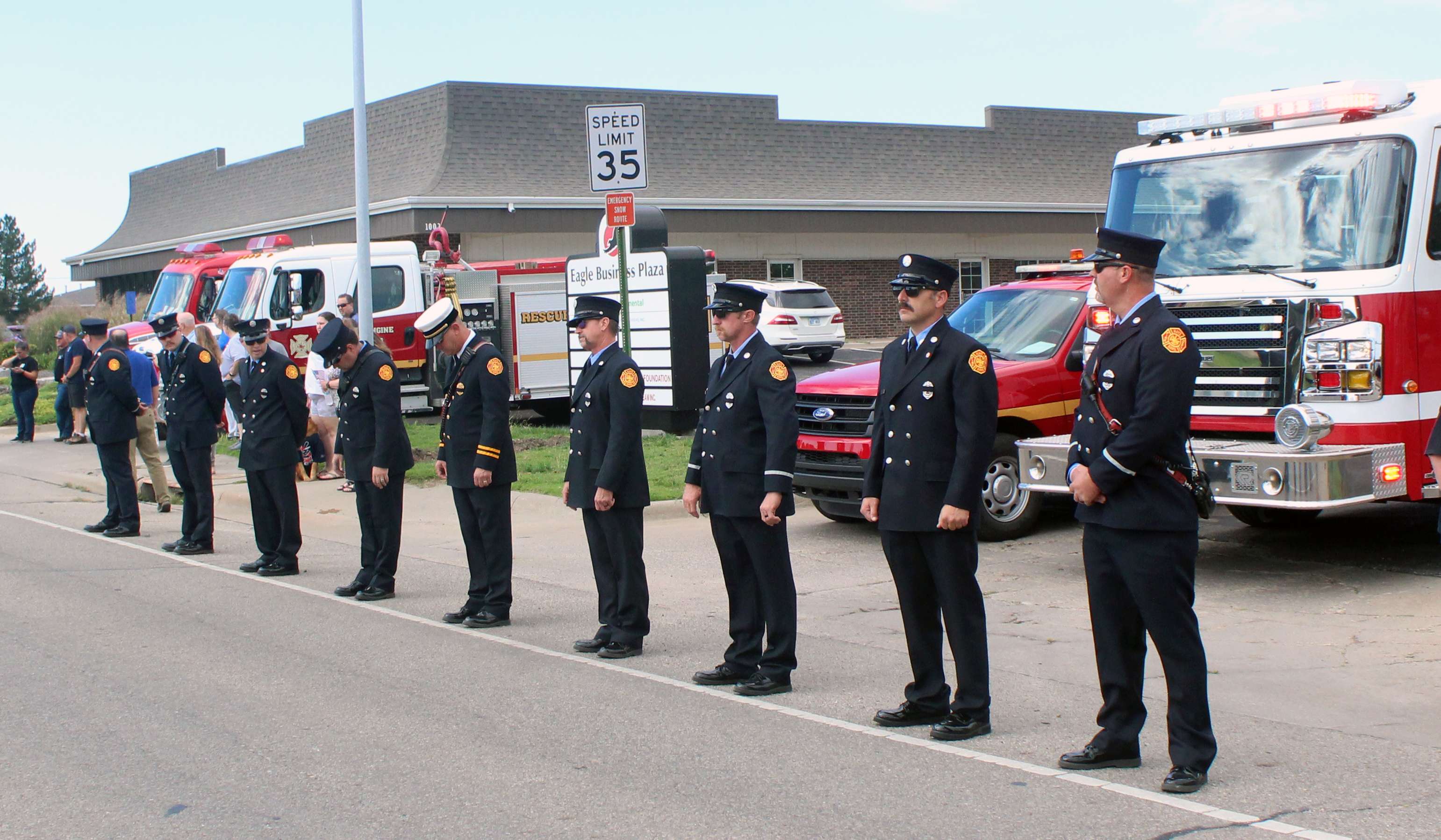 Hays firefighters stand at attention in dress blues, awaiting the arrival of the escort for Sgt. Scott Heimann's remains as they are brought  back to Hays. Heimann was killed in the line of duty on Sunday.&nbsp;Photo by Cristina Janney/Hays Post