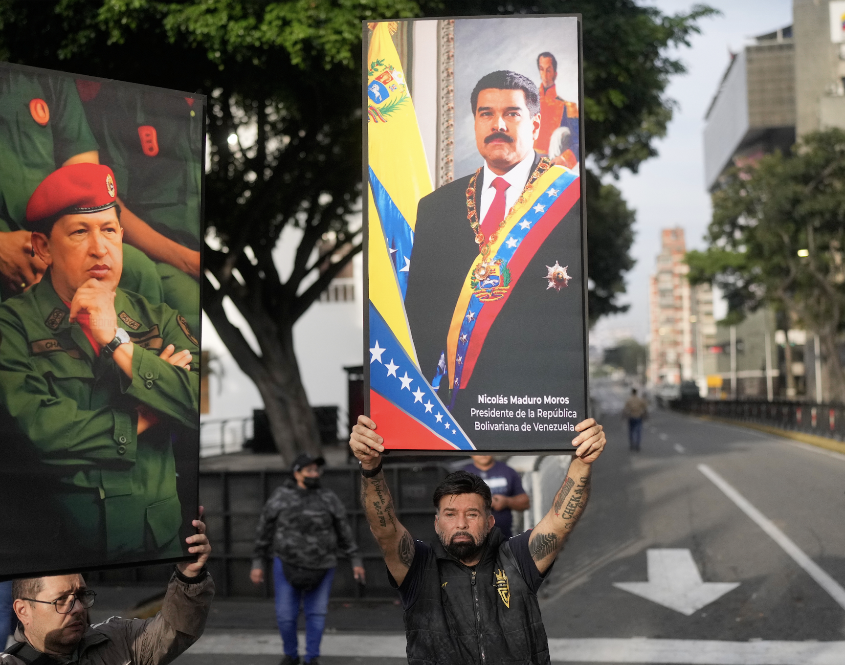 Government supporters display posters of Venezuelan President Nicolás Maduro, right, and former President Hugo Chávez in downtown Caracas, Venezuela, Saturday, Jan. 3, 2026, after U.S. President Donald Trump announced that Maduro had been captured and flown out of the country. (AP Photo/Matias Delacroix)