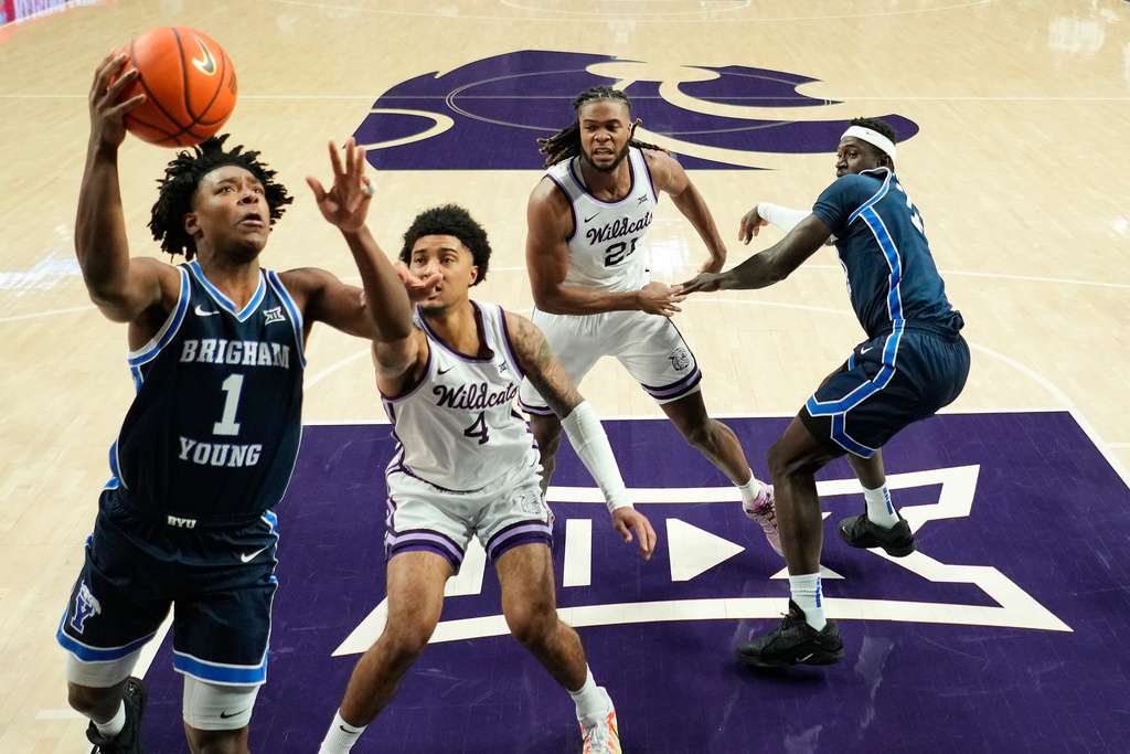 BYU guard Robert Wright III (1) gets past Kansas State guard P.J. Haggerty (4) to put up a shot during the first half of an NCAA college basketball game Saturday, Jan. 3, 2026, in Manhattan, Kan. (AP Photo/Charlie Riedel)