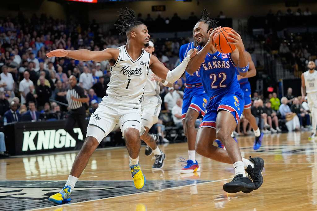 Kansas guard Darryn Peterson (22) makes a move to get past Central Florida guard Themus Fulks (1) during the first half of an NCAA college basketball game, Saturday, Jan. 3, 2026, in Orlando, Fla. (AP Photo/John Raoux)