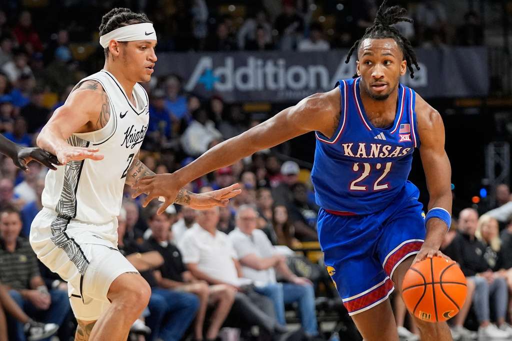 Kansas guard Darryn Peterson (22) drives past Central Florida guard Riley Kugel during the first half of an NCAA college basketball game, Saturday, Jan. 3, 2026, in Orlando, Fla. (AP Photo/John Raoux)