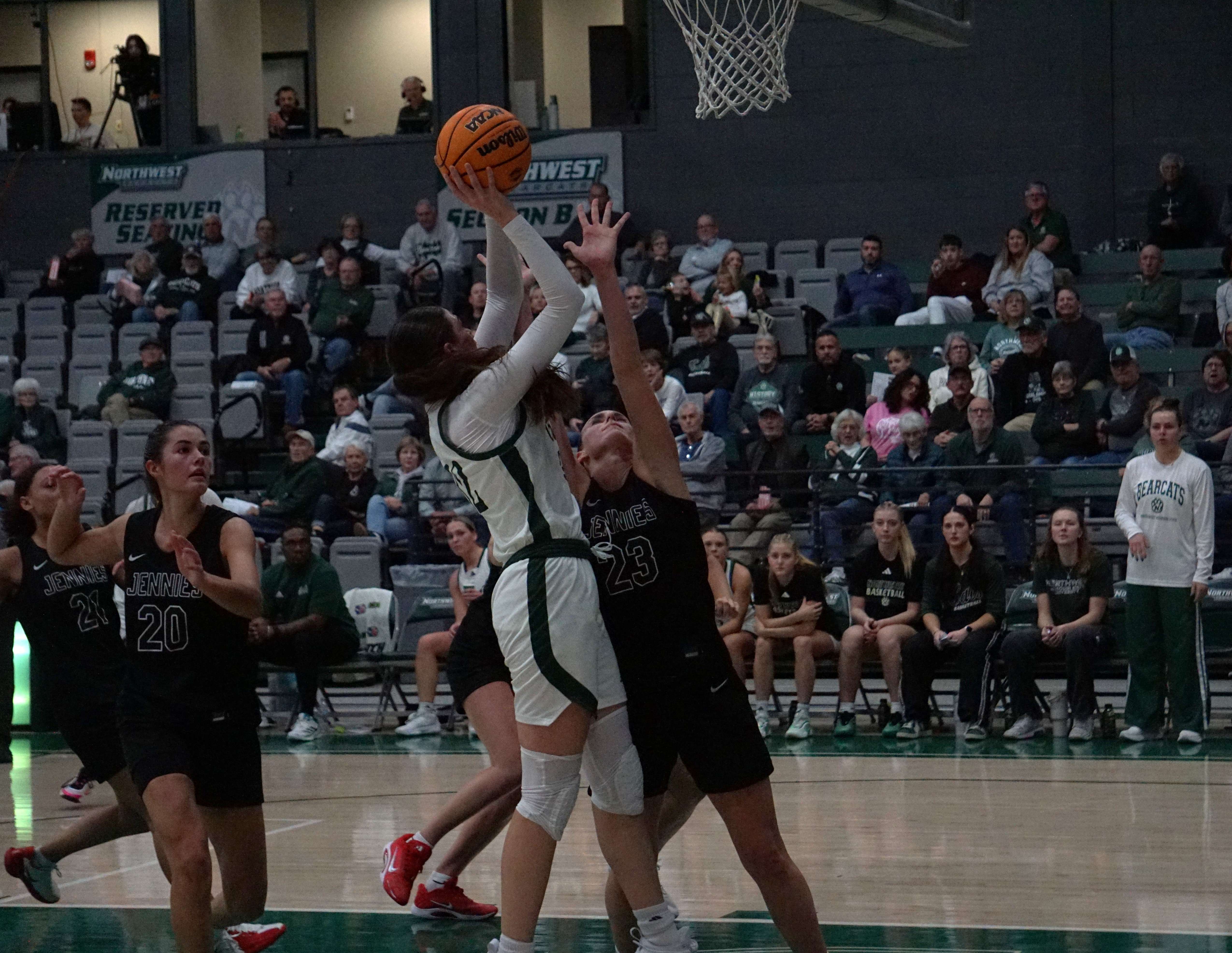 Northwest's Sadie Maas goes hard into the paint against UCM's Reese Schaaf (23)/ Photo by Matt Pike