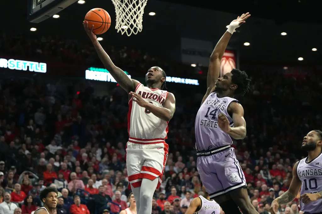 Arizona guard Jaden Bradley (0) drives past Kansas State guard Mobi Ikegwuruka during the second half of an NCAA college basketball game, Wednesday, Jan. 7, 2026, in Tucson, Ariz. (AP Photo/Rick Scuteri)
