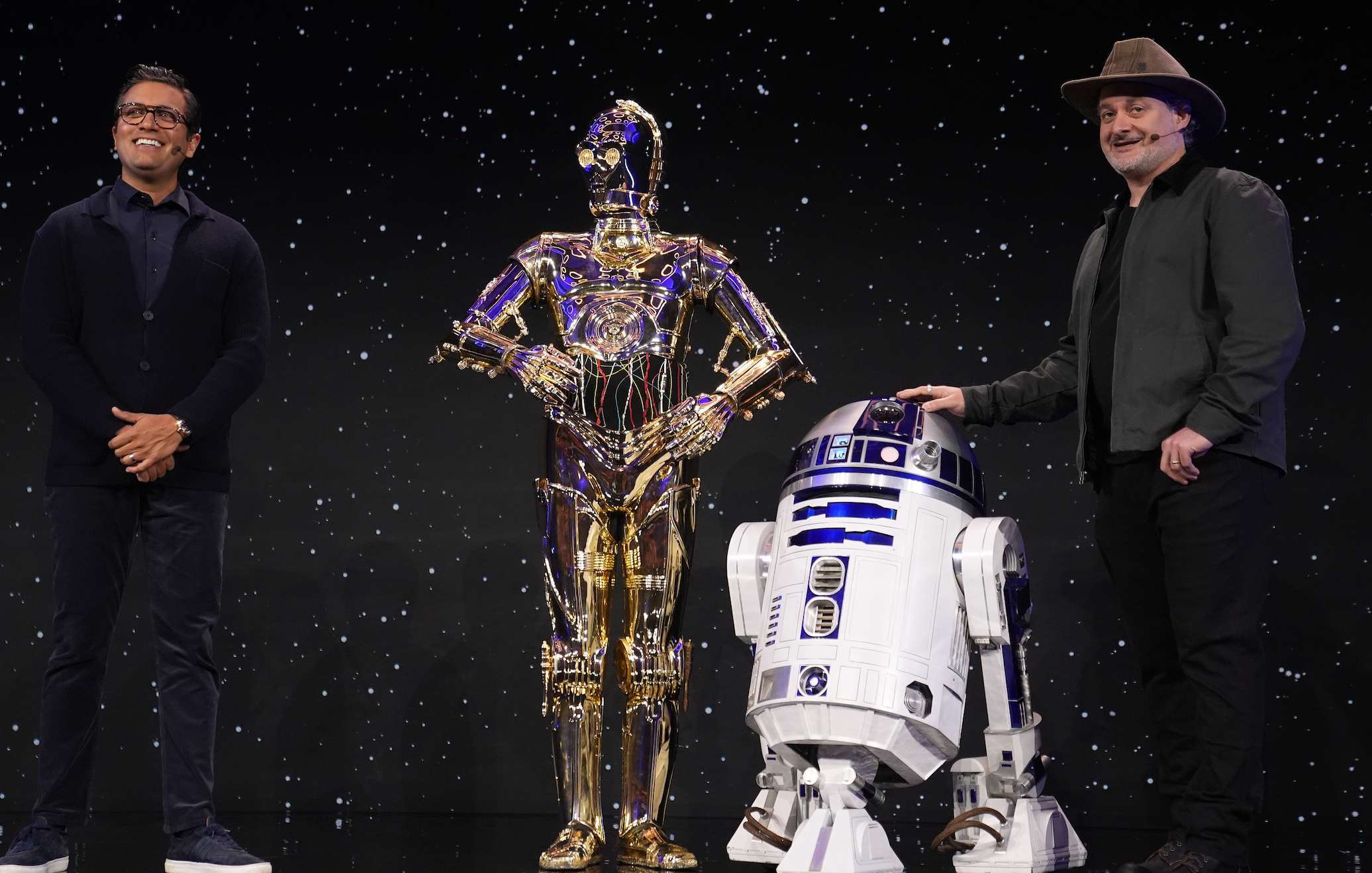 Asad Ayaz, left, and Dave Filioni stand on stage with C-3PO and R2-D2 during an LEGO news conference ahead of the CES tech show Monday, Jan. 5, 2026, in Las Vegas. (AP Photo/Abbie Parr)