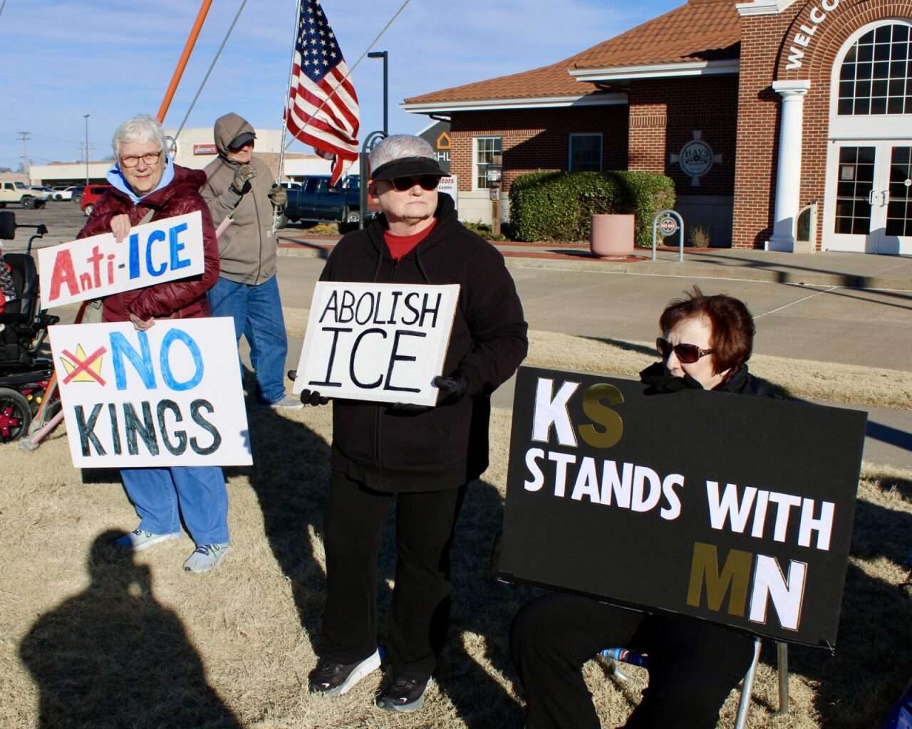 Protesters with signs Sunday on the corner of 27th and Vine streets in Hays. Photo by Tony Guerrero/Hays Post