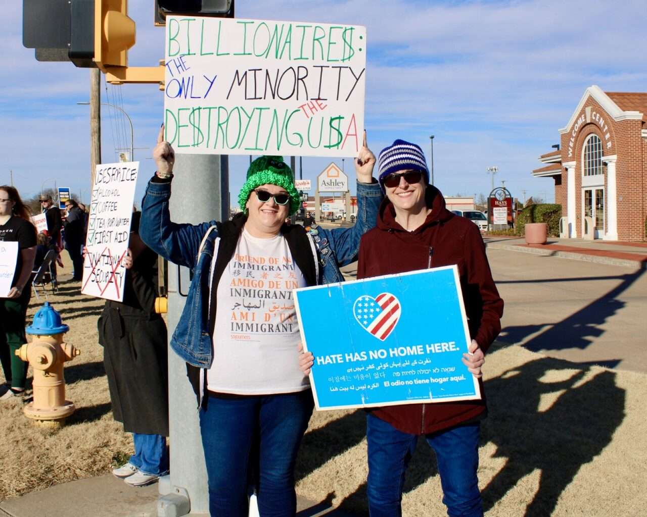 Protesters with signs Sunday on the corner of 27th and Vine streets in Hays. Photo by Tony Guerrero/Hays Post