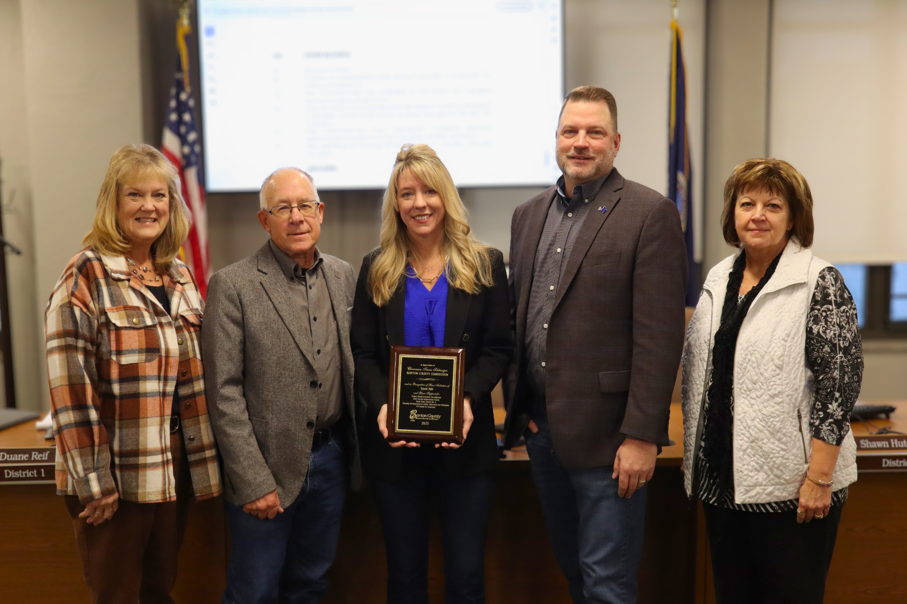 The Barton County Commission following its 2026 leadership elections. Pictured from left to right: Commissioners Barb Esfeld, Duane Reif, former Chair Tricia Schlessiger (center), Shawn Hutchinson, and Donna Zimmerman. Commissioner Schlessiger was recognized with a commemorative plaque honoring her service and leadership during 2025.