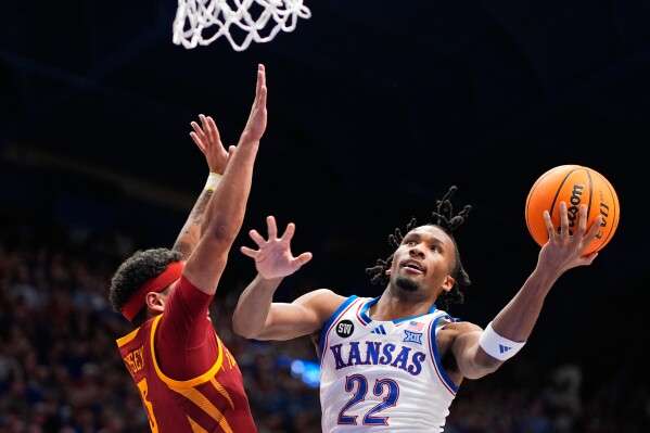 Kansas guard Darryn Peterson (22) shoots over Iowa State forward Joshua Jefferson (5) during the first half of an NCAA college basketball game Tuesday, Jan. 13, 2026, in Lawrence, Kan. (AP Photo/Charlie Riedel)