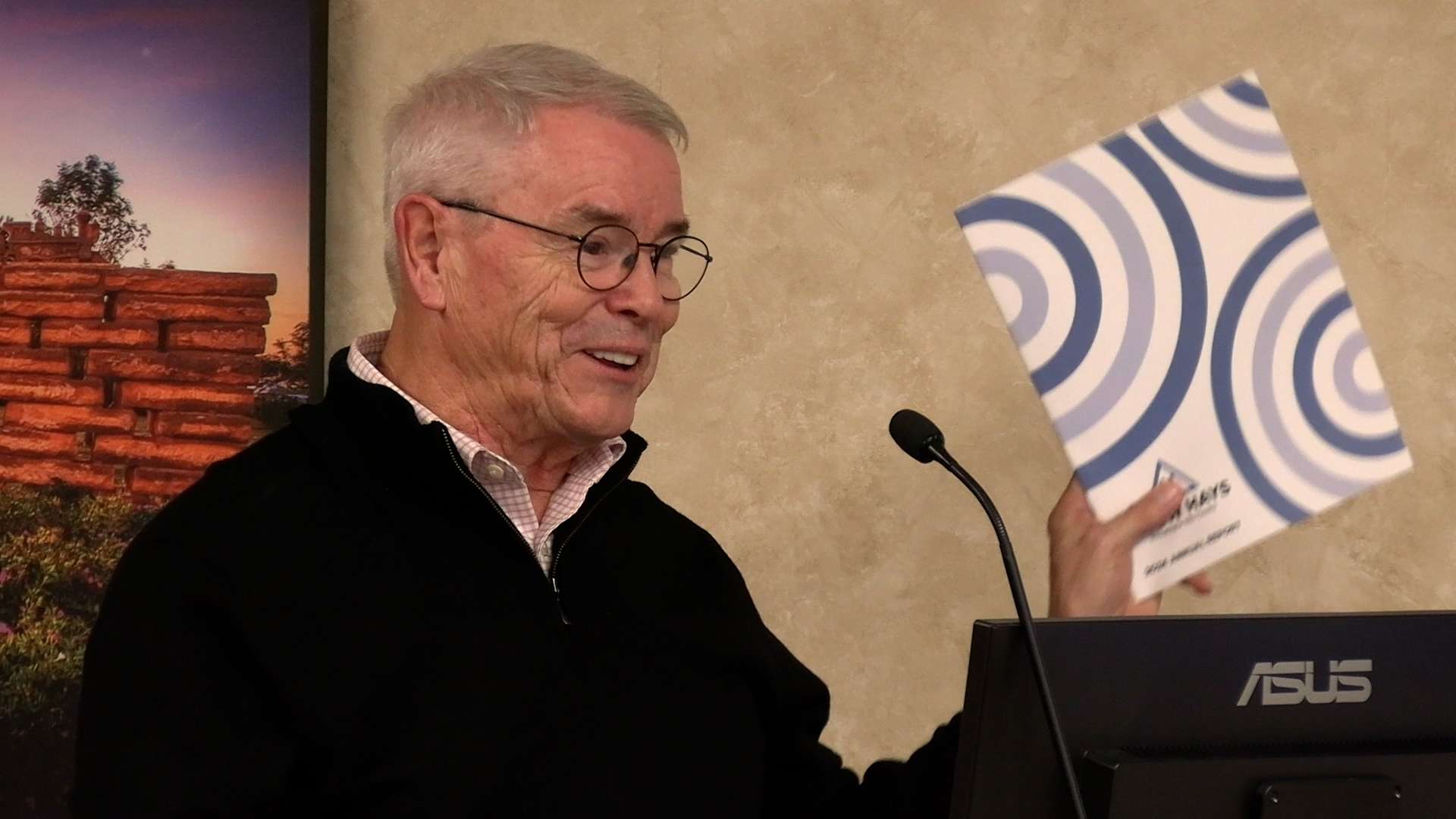 Doug Williams, Grow Hays executive director, shows a copy of his 2025 annual review to Hays city commissioners Thursday. Photo by Becky Kiser/Hays Post