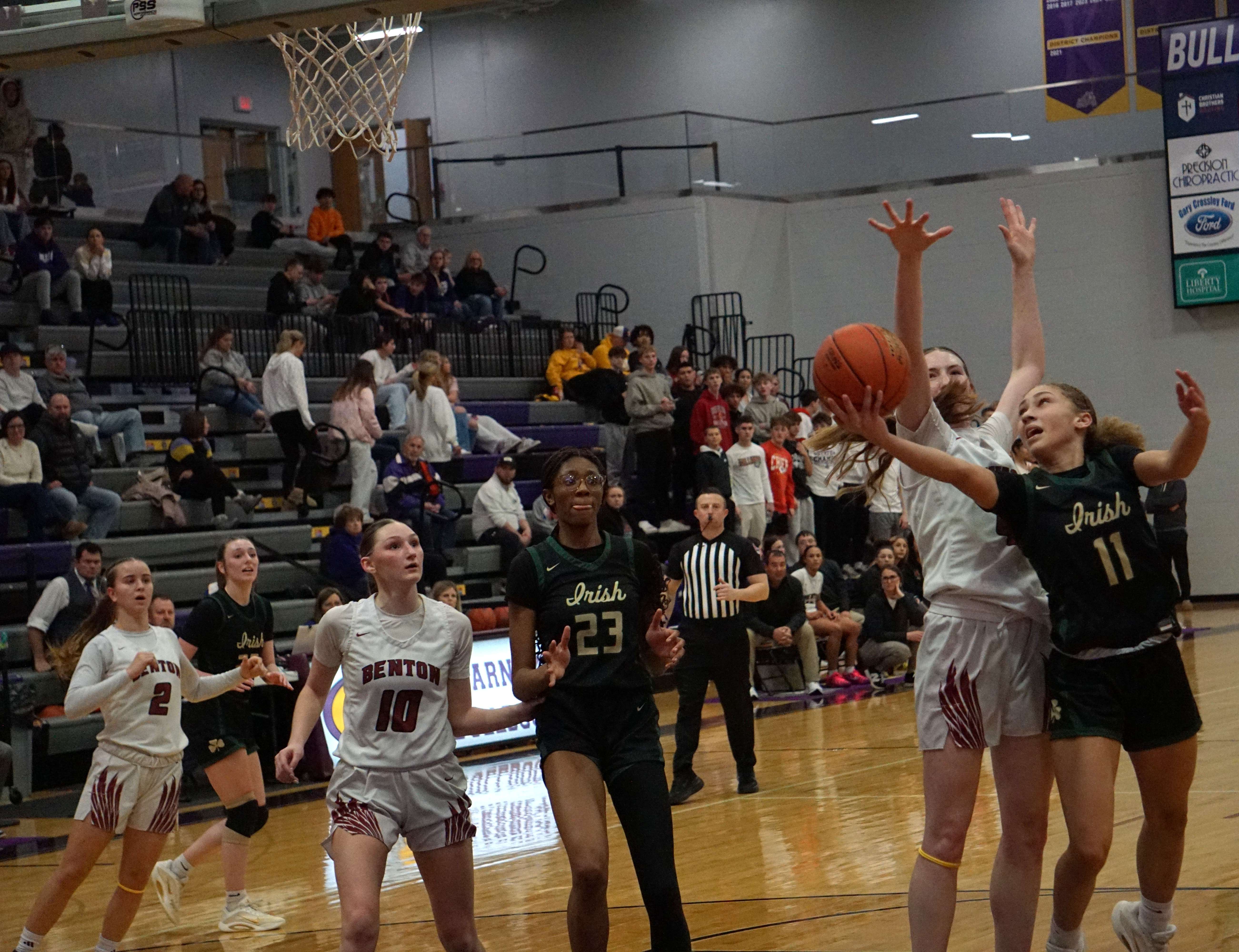 Rozlyn McDevitt (11) goes for a contested layup against Benton's Jenna Cox/ Photo by Matt Pike