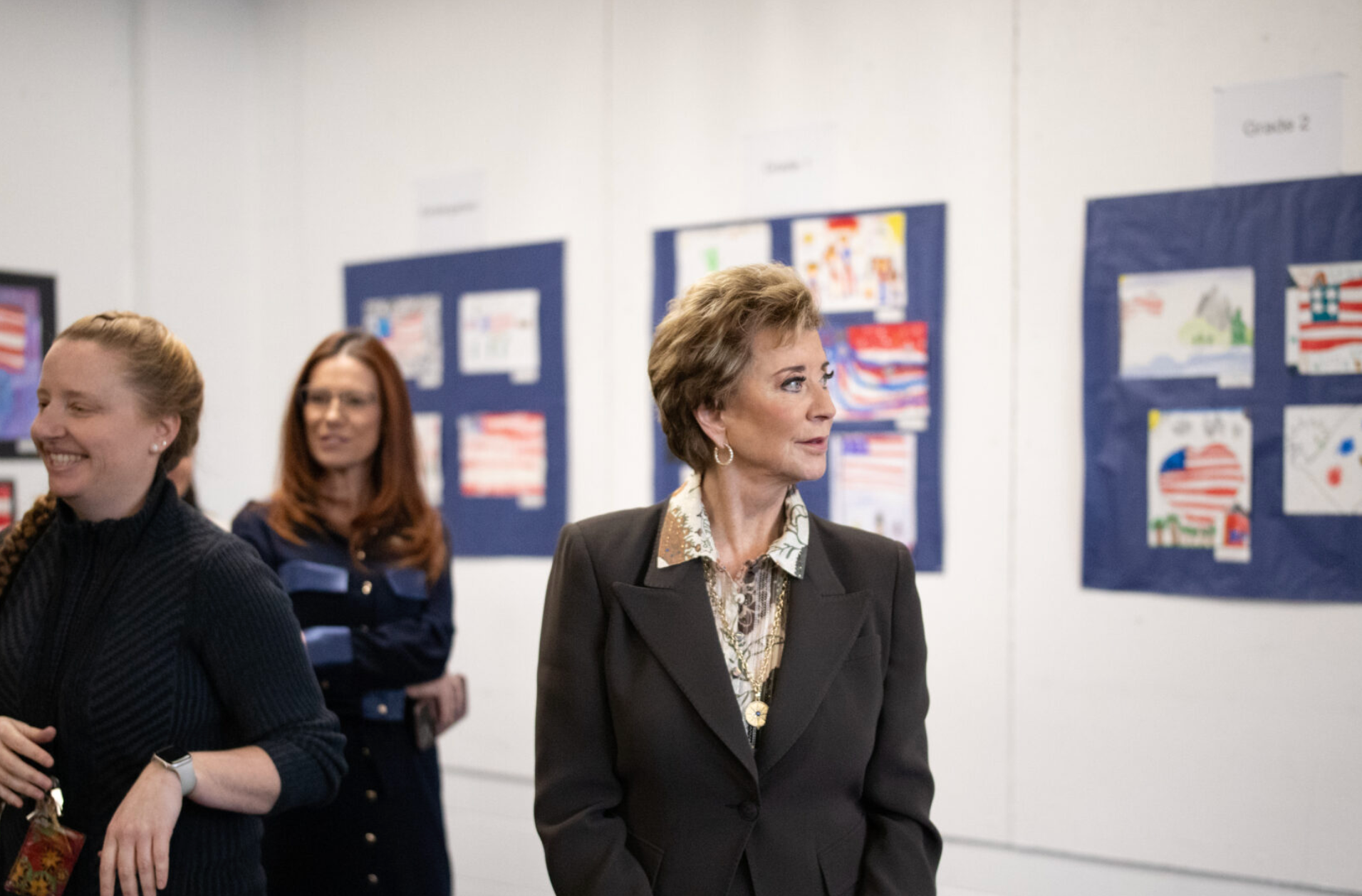 U.S. Education Secretary Linda McMahon takes in a selection of grade school students’ patriotic artworks and high schoolers’ recent output in a special installation set up at Exeter-West Greenwich Regional Junior High and High School in Rhode Island on Monday, Jan. 12, 2026. (Photo by Alexander Castro/Rhode Island Current)