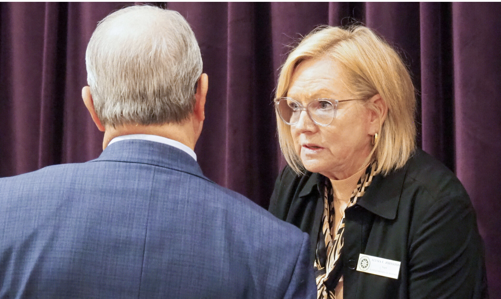 Kansas Board of Regents member Alysia Johnston, who leads the board’s academic affairs committee, endorses faculty workload and post-tenure review policies applicable at the six public universities in the state system. This image of Johnston is of her at a Board of Regents meeting in 2024 in Manhattan. (Photo by Tim Carpenter/Kansas Reflector)