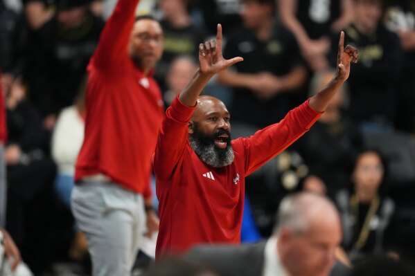 Kansas assistant coach Jacque Vaughn, center, signals to players in the second half of an NCAA college basketball game against Colorado Tuesday, Jan. 20, 2026, in Boulder, Colo. (AP Photo/David Zalubowski)