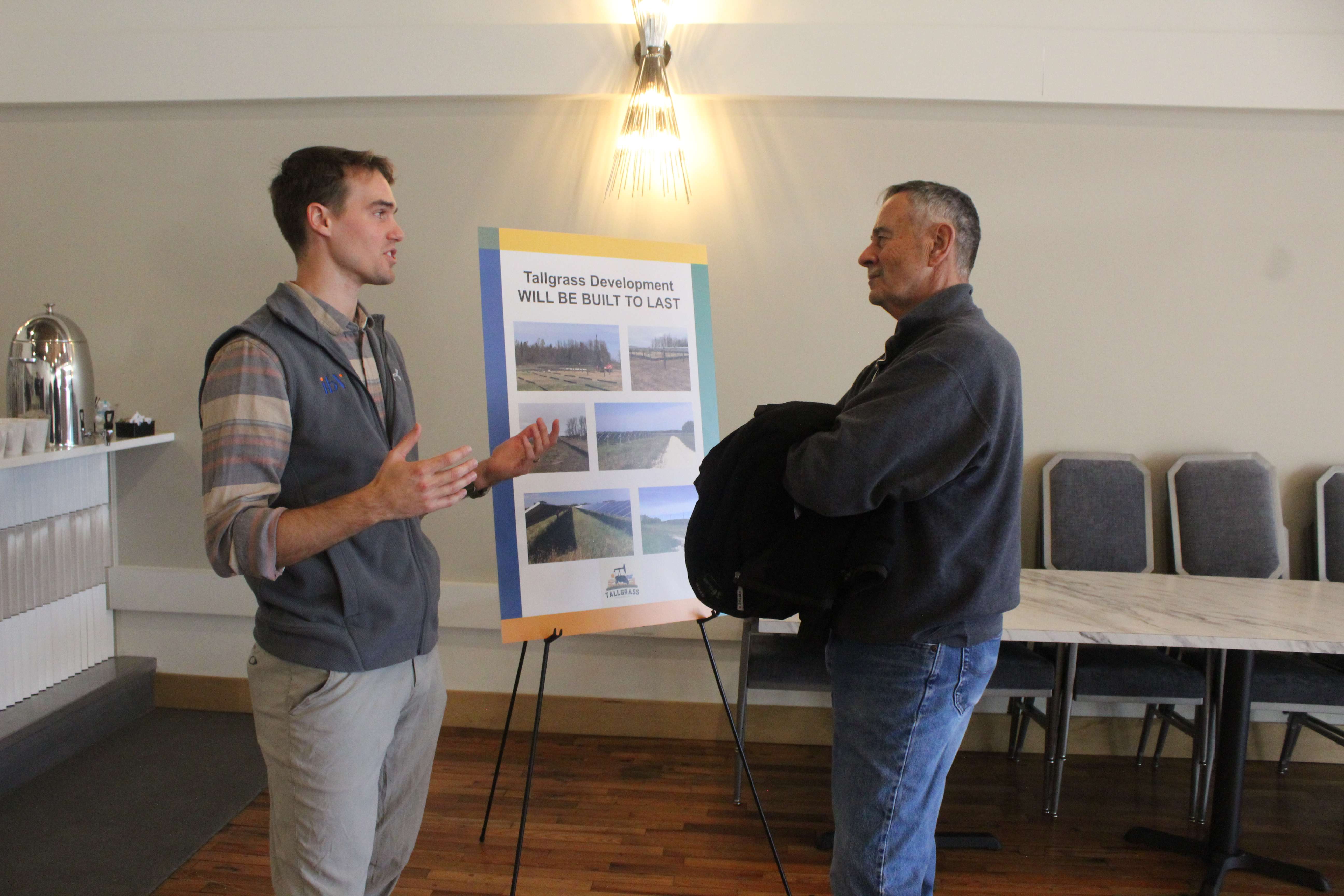 Jack Leesnitzer, left, ibV planning and engineering manager, shares details of the construction phase of the proposed solar project with a resident at Thursday's open house. Photo by Cristina Janney/Hays Post