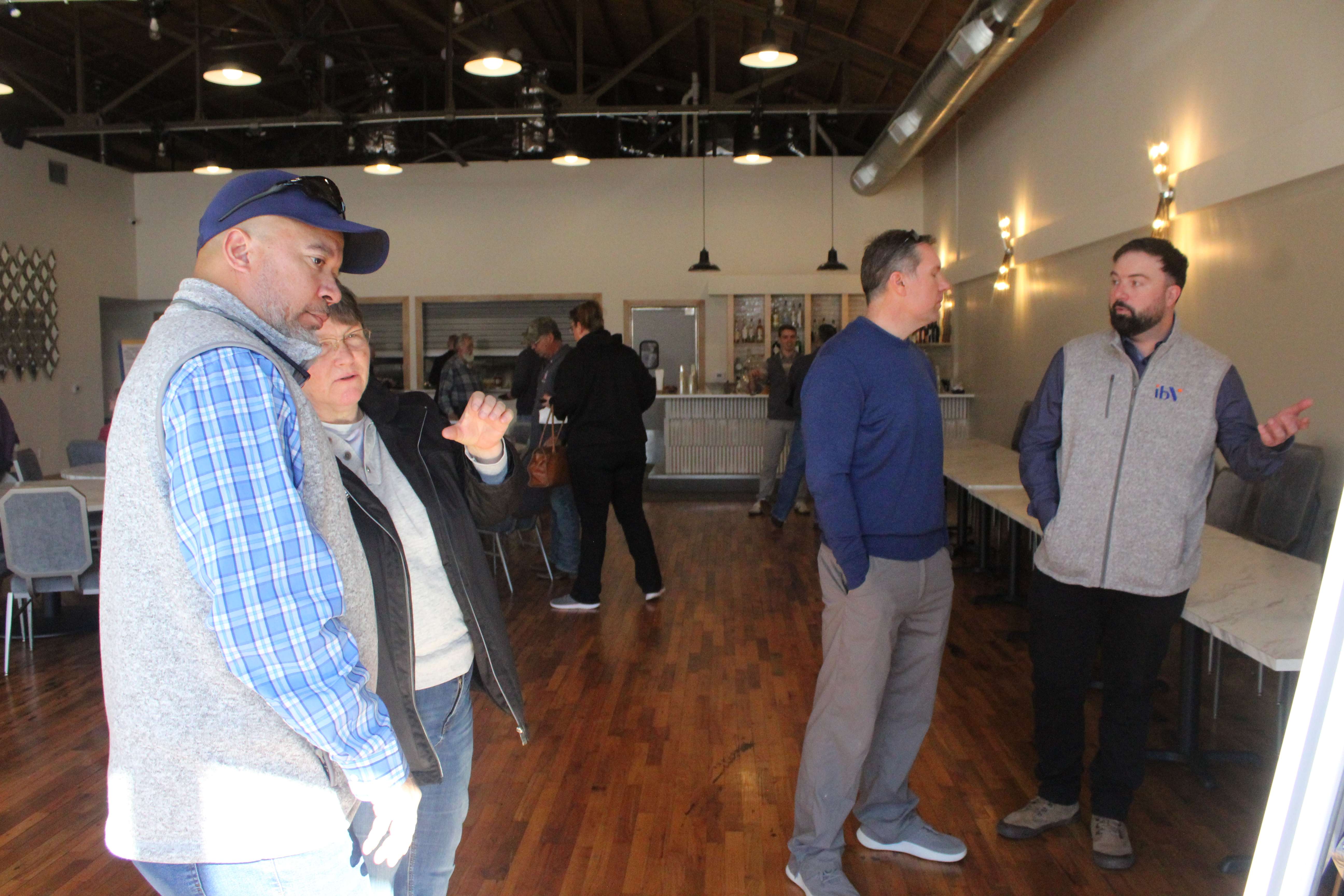 Steven Link, far left, ibV senior project developer, and Patrick Ripa, far right, ibV executive director of planning and engineering, discuss project maps during an open house in Hays on Thursday. Photo by Cristina Janney/Hays Post