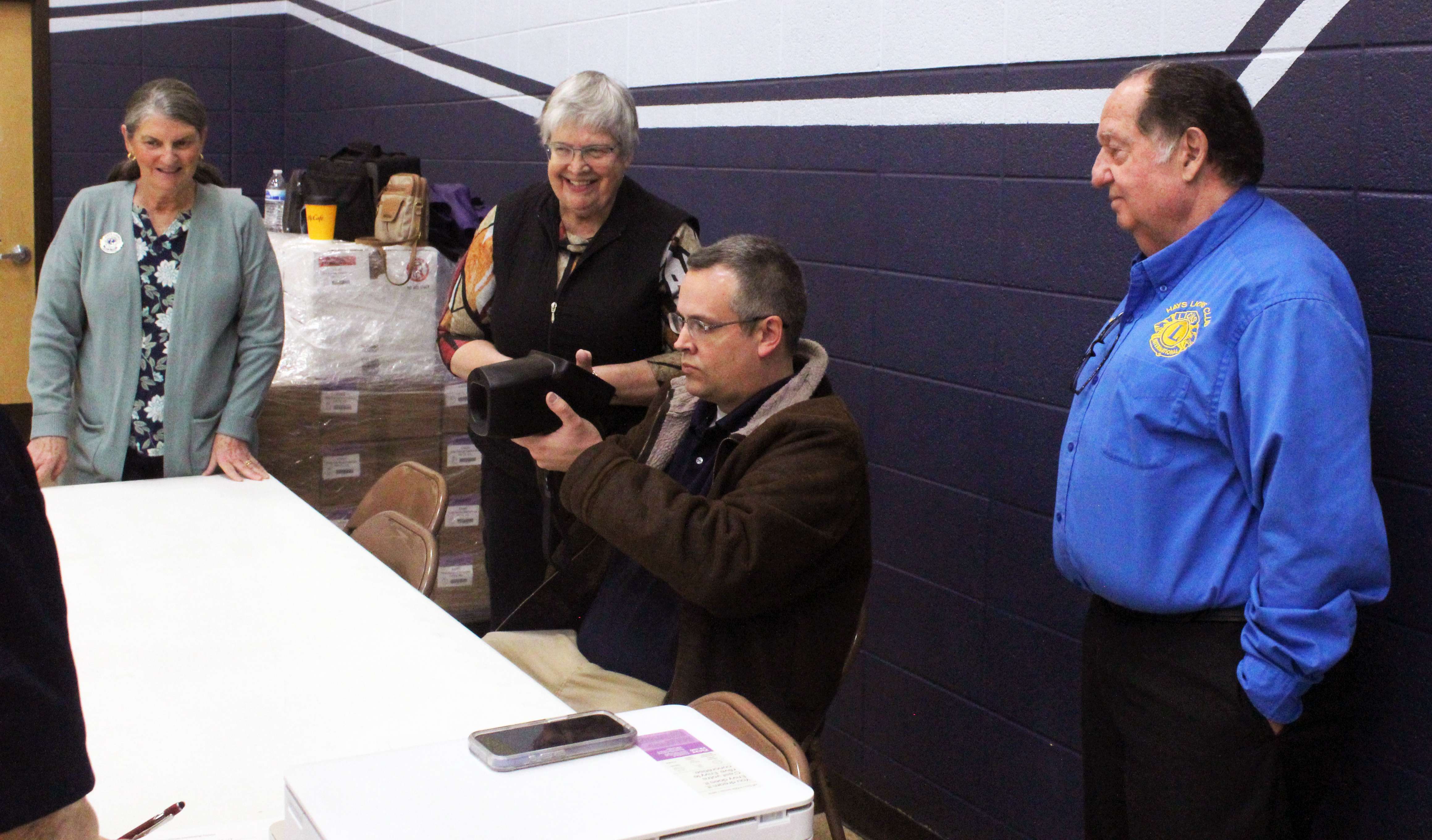 Jim Huenergarde, far right, helps screen students for vision issues at Holy Family Elementary School. Huenergarde serves as vice president of the Kansas Lions Sight Foundation and leads its Finance and Investment Committee. Photo by Cristina Janney/Hays Post